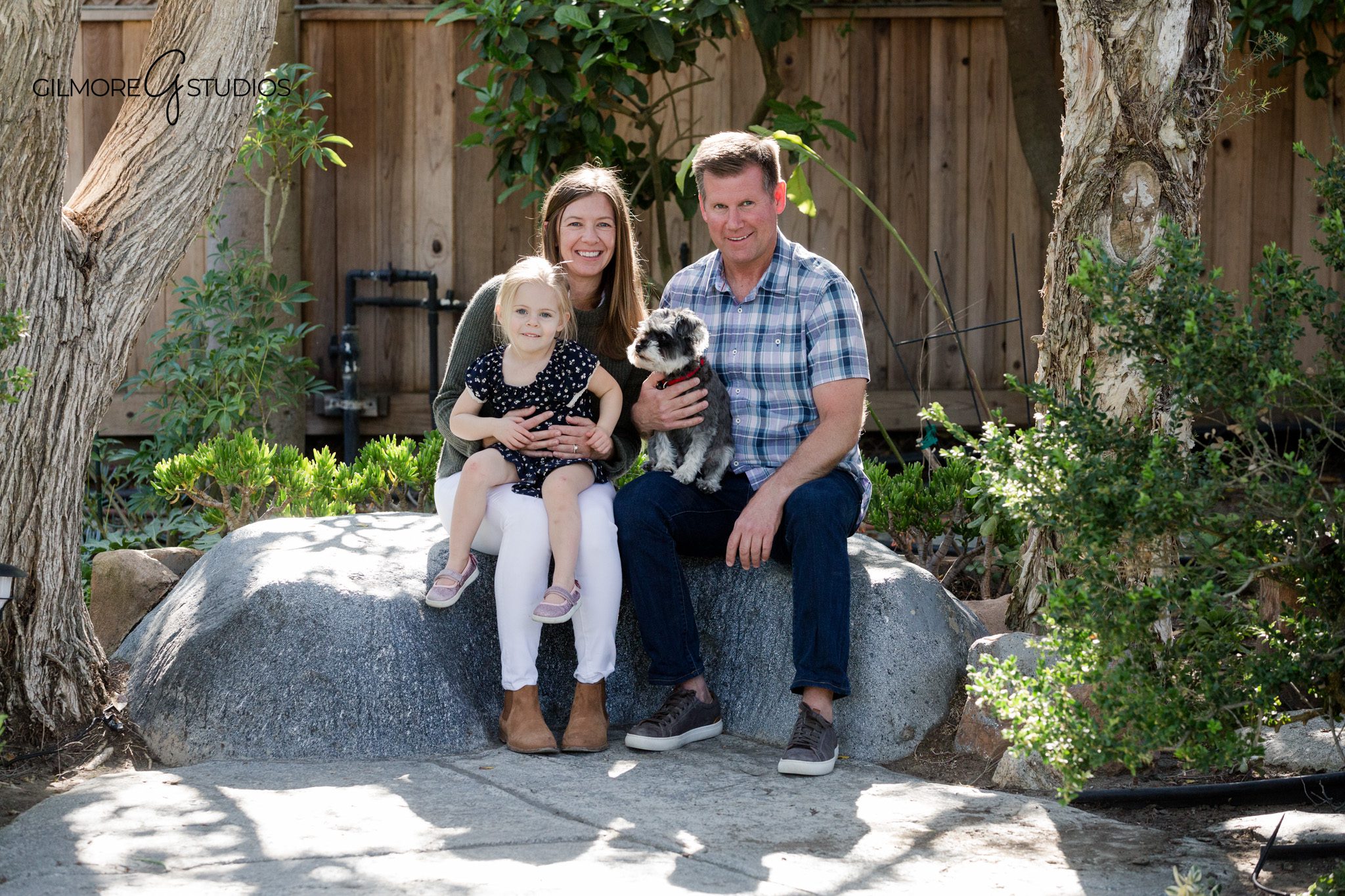 Backyard garden family photos with parents and children in soft natural light
Family photographer capturing portraits in a backyard garden setting