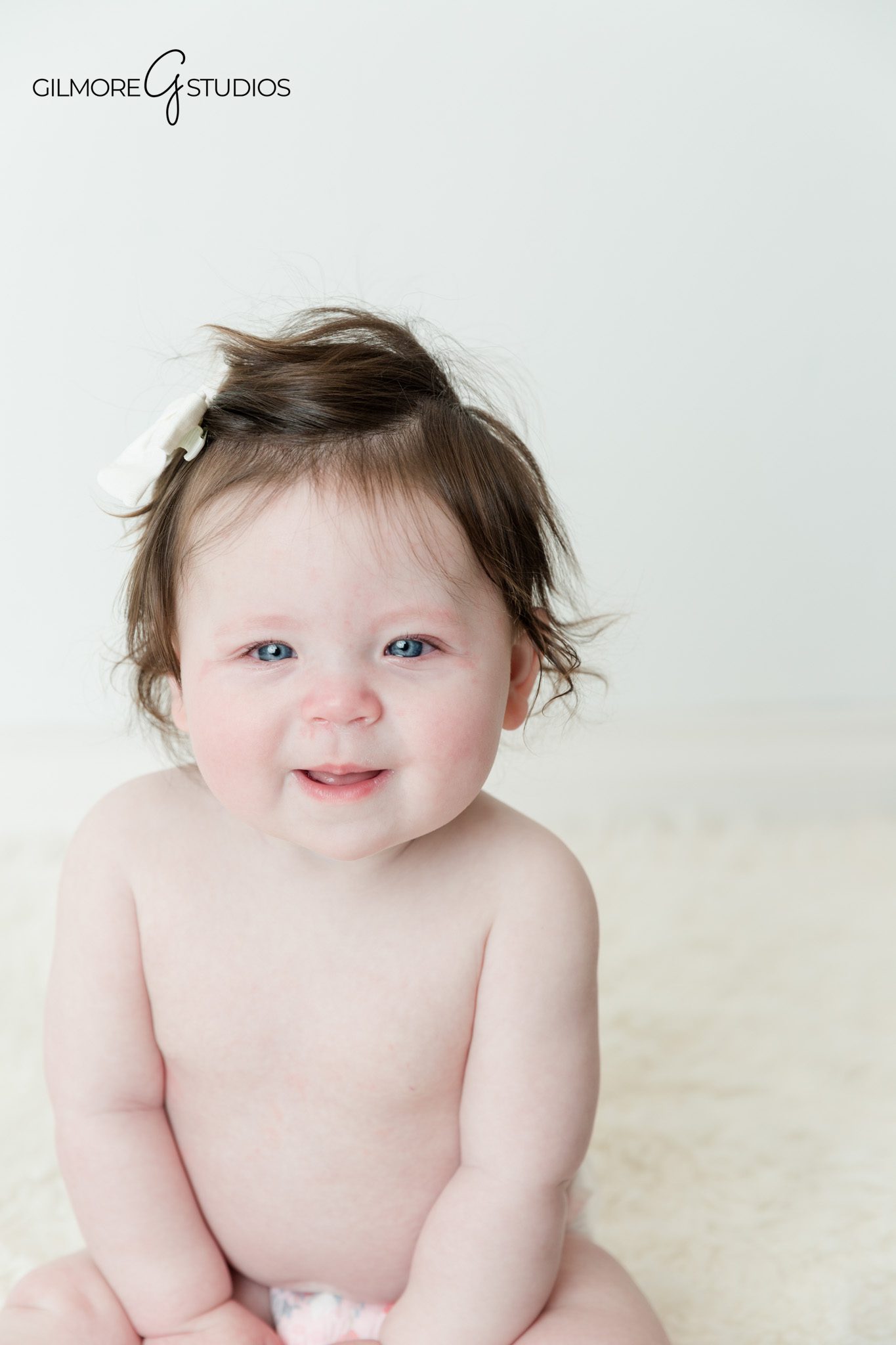 Baby sitting up photos with bright eyes and natural expression
Studio baby milestone session with soft timeless backdrop