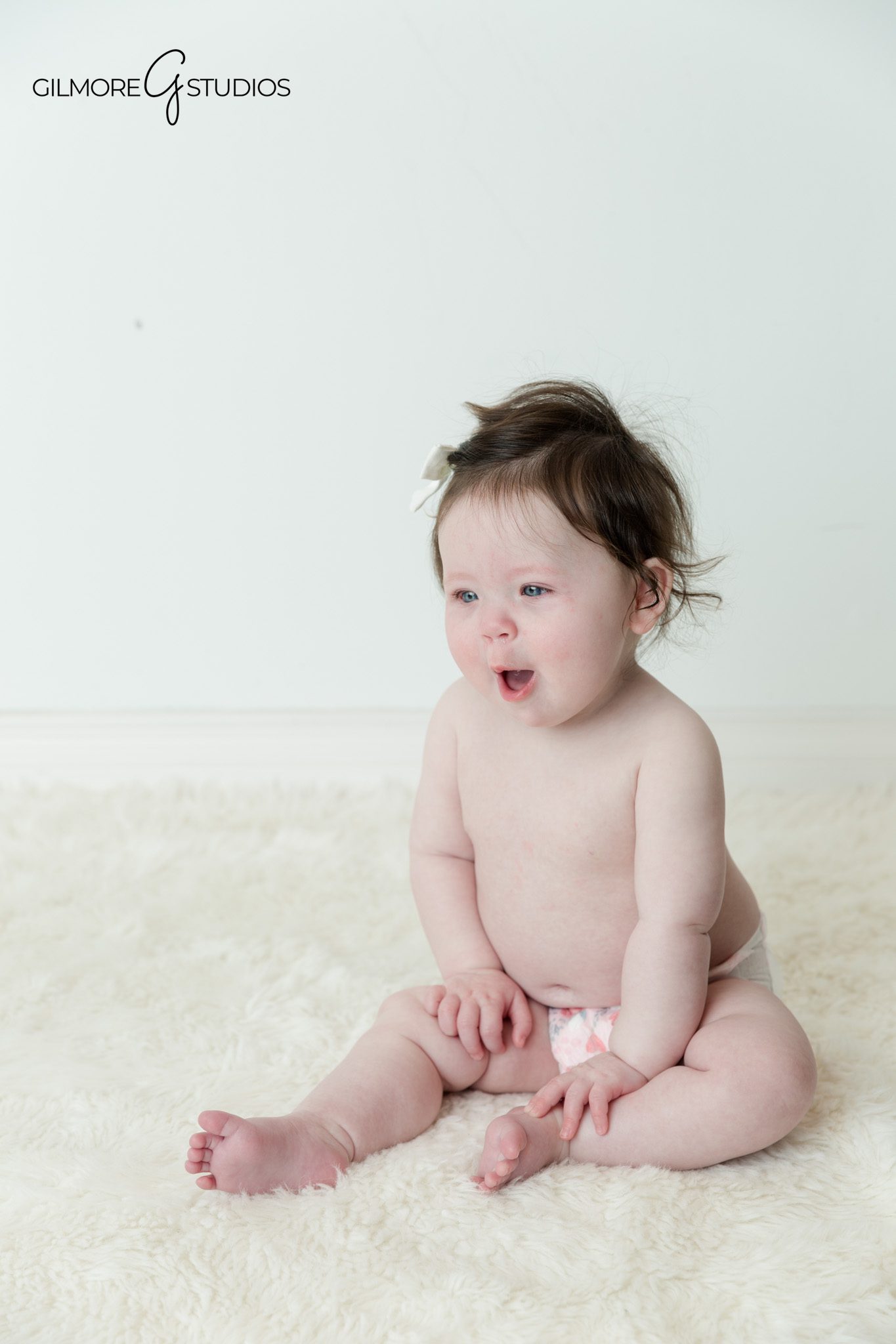 Baby sitting up independently in clean studio portrait setup
Gilbert Arizona baby milestone photographer capturing sitter photos