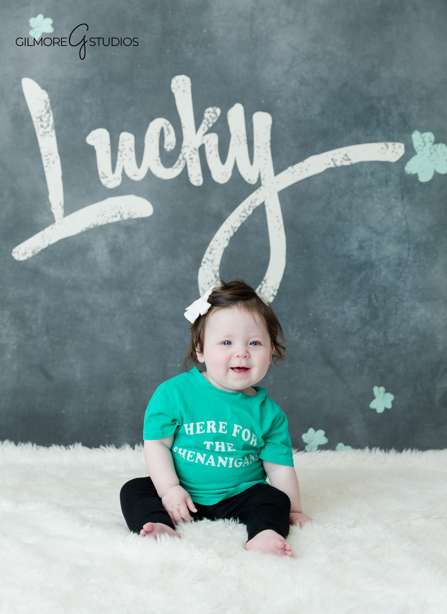 Sitting up milestone session with baby reaching for small toy
Baby milestone photography with soft florals and neutral colors