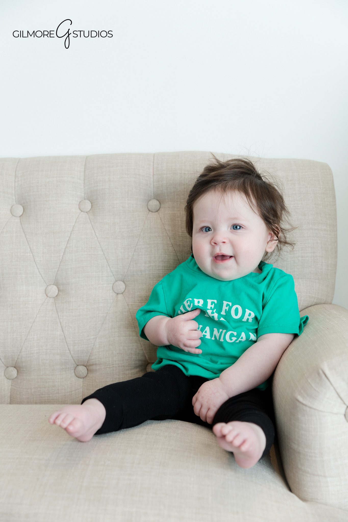 Sitter milestone session with baby smiling toward parents
Baby sitting independently with hands resting on lap during portraits