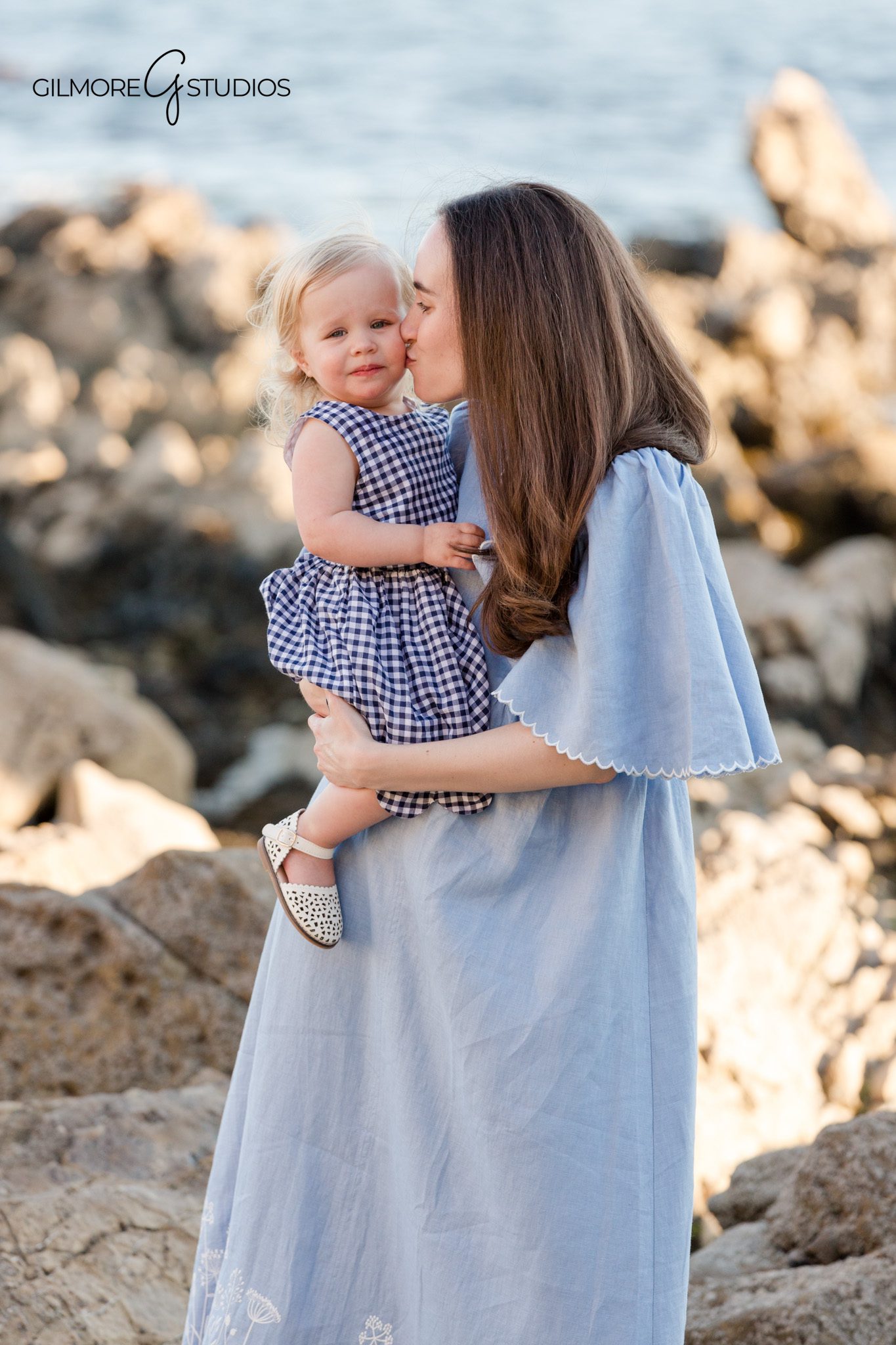 Orange County beach photographer capturing grandparents with all grandchildren
Newport Beach family portraits with rocky coastline and soft ocean colors