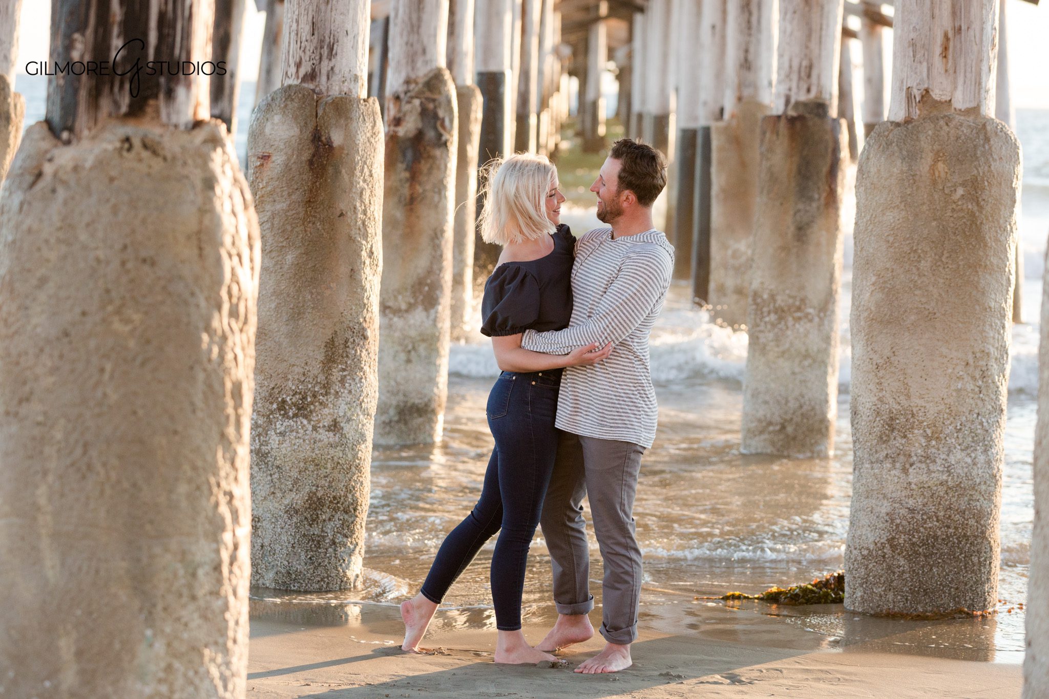 Family walking hand in hand along the shoreline at Newport Pier
Golden hour beach portraits for family at Newport Beach Pier