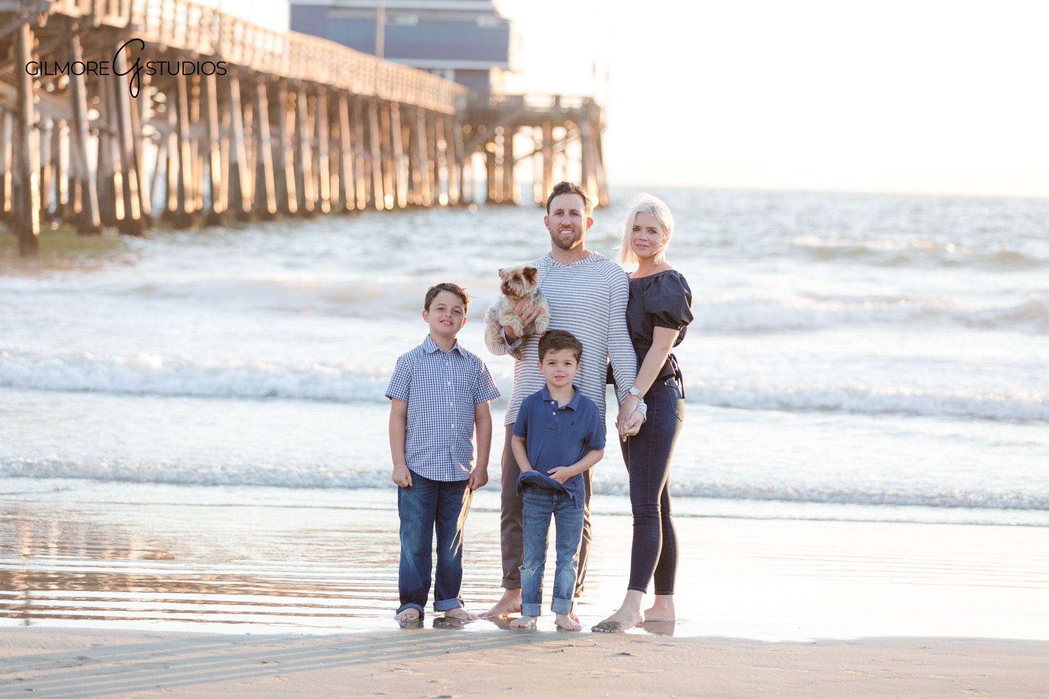 Newport Pier beach session with classic family portraits and candid moments
Family standing at the water’s edge during Newport Beach sunset session
