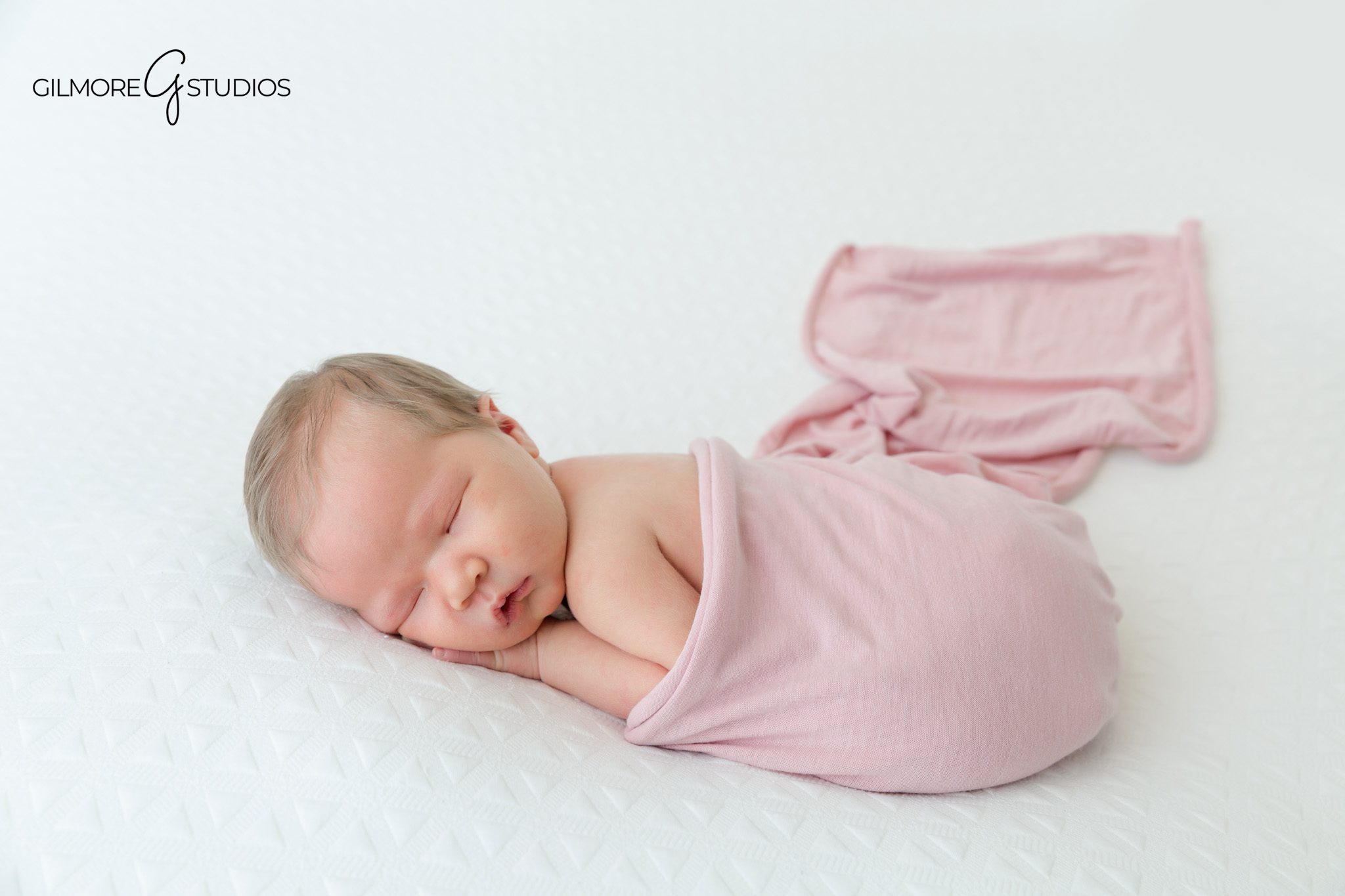 Sleeping newborn girl with pink wrap and floral crown on white blanket
Soft pink newborn studio portrait for baby girl in Chandler AZ