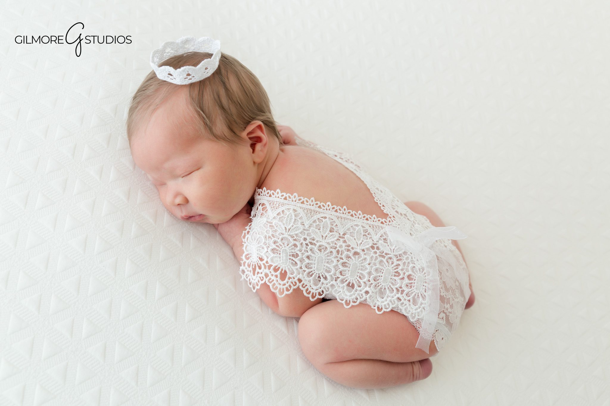 Newborn portrait with blush wrap, floral crown, and clean white background
Baby girl sleeping peacefully during a Chandler newborn studio session
