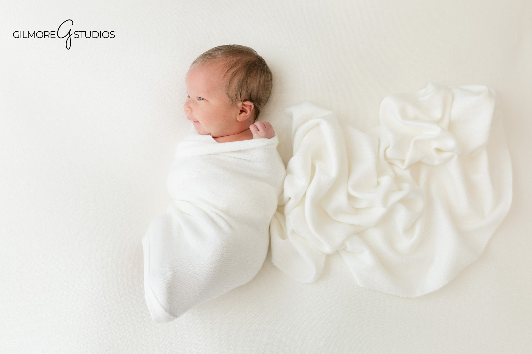 Newborn baby wearing a pink floral headband in a soft studio portrait
Chandler newborn photographer capturing baby wrapped in blush pink