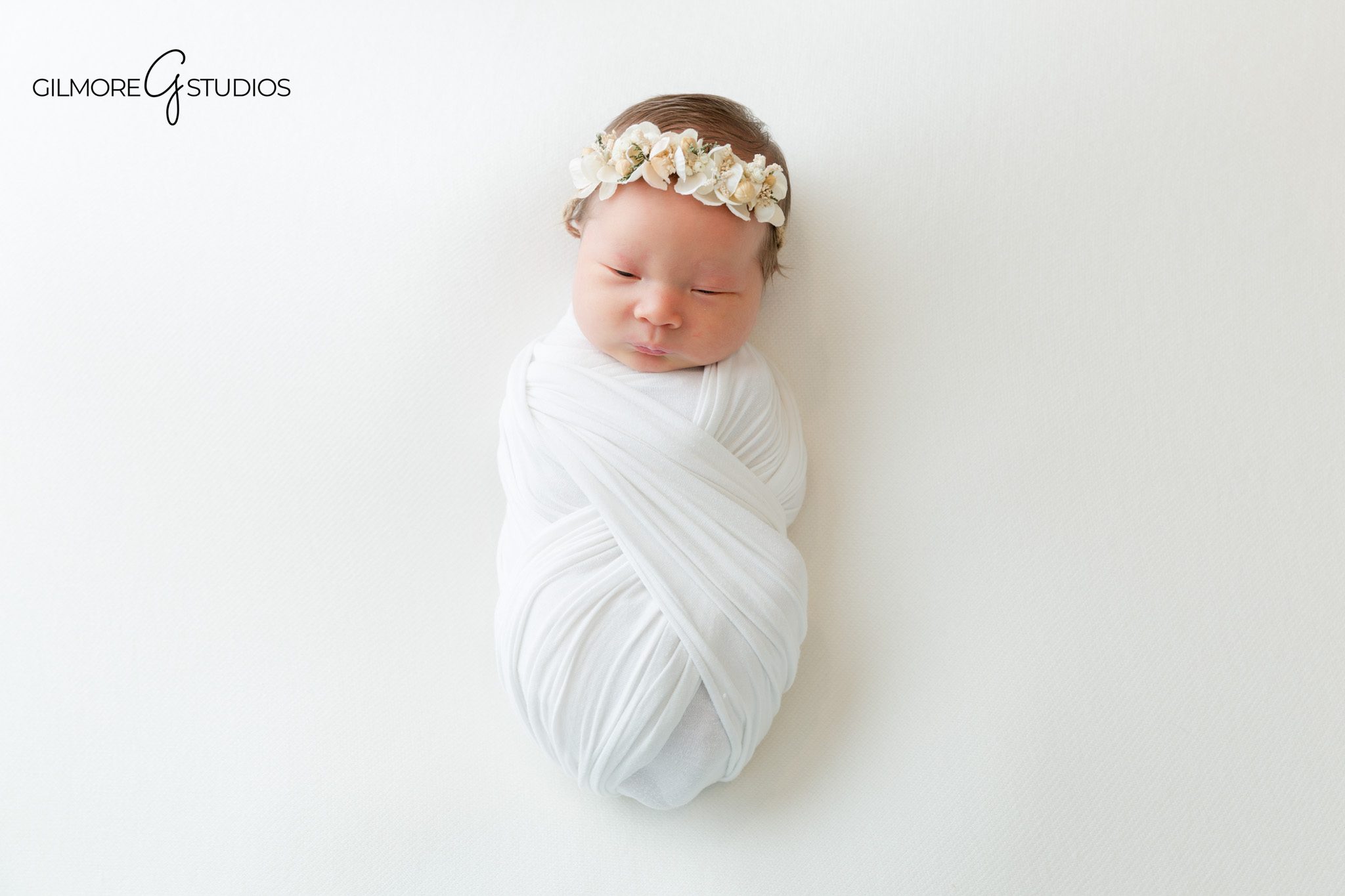 Newborn baby posed on tummy with floral headband and pink wrap
Chandler AZ baby girl newborn photos with soft feminine styling