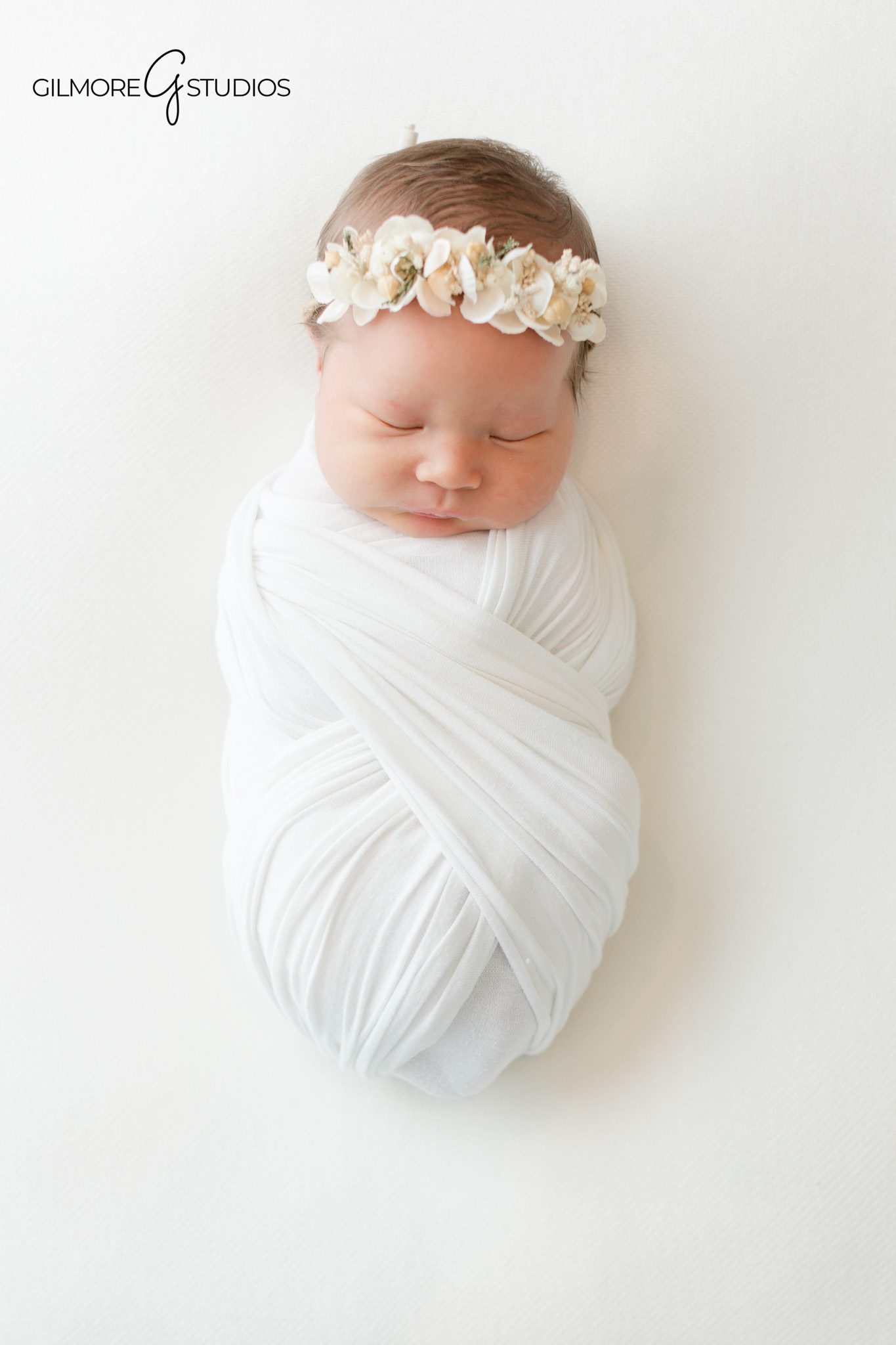 Chandler newborn photography session with parents holding their sleeping baby
Simple newborn studio portrait with baby and parents on a white background