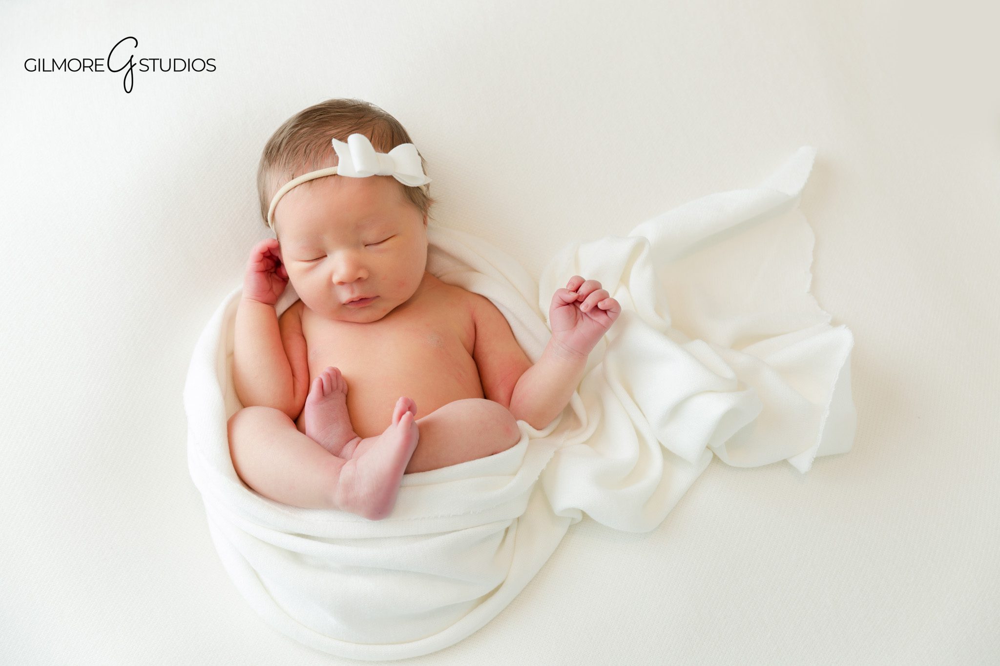 Baby sleeping in a bunny bonnet during Chandler AZ newborn photos
Neutral newborn photography setup with baby posed on a white blanket