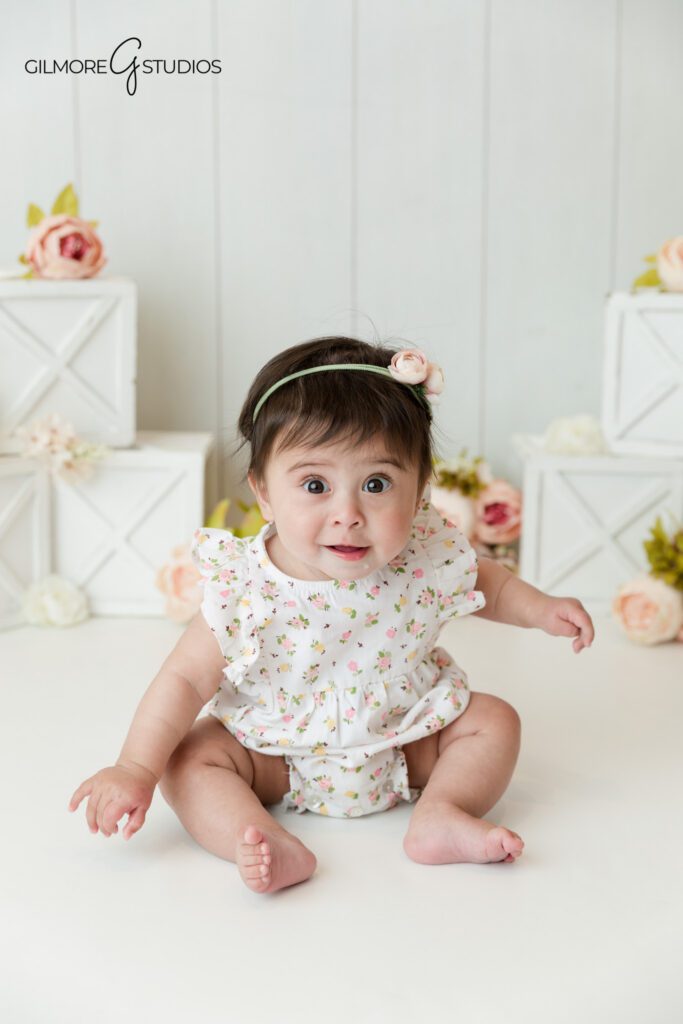Sitting up baby girl session with delicate floral styling
Baby milestone photos with soft pink and white studio details