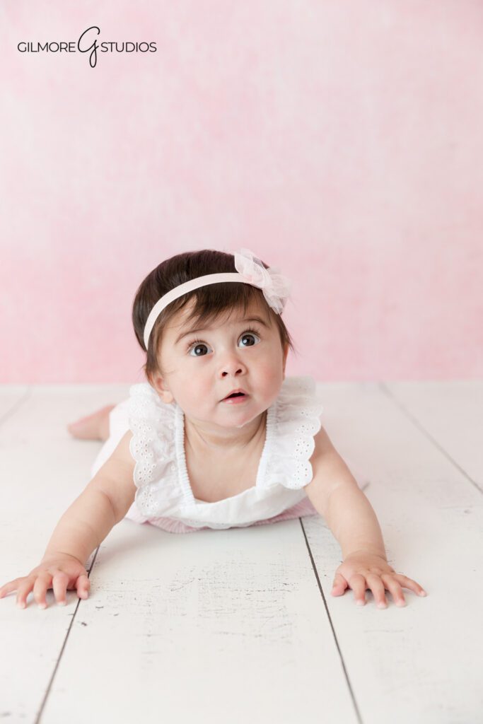 Sitting up baby milestone portrait with white crates and soft flowers
Gilbert baby photographer capturing a baby girl sitting independently