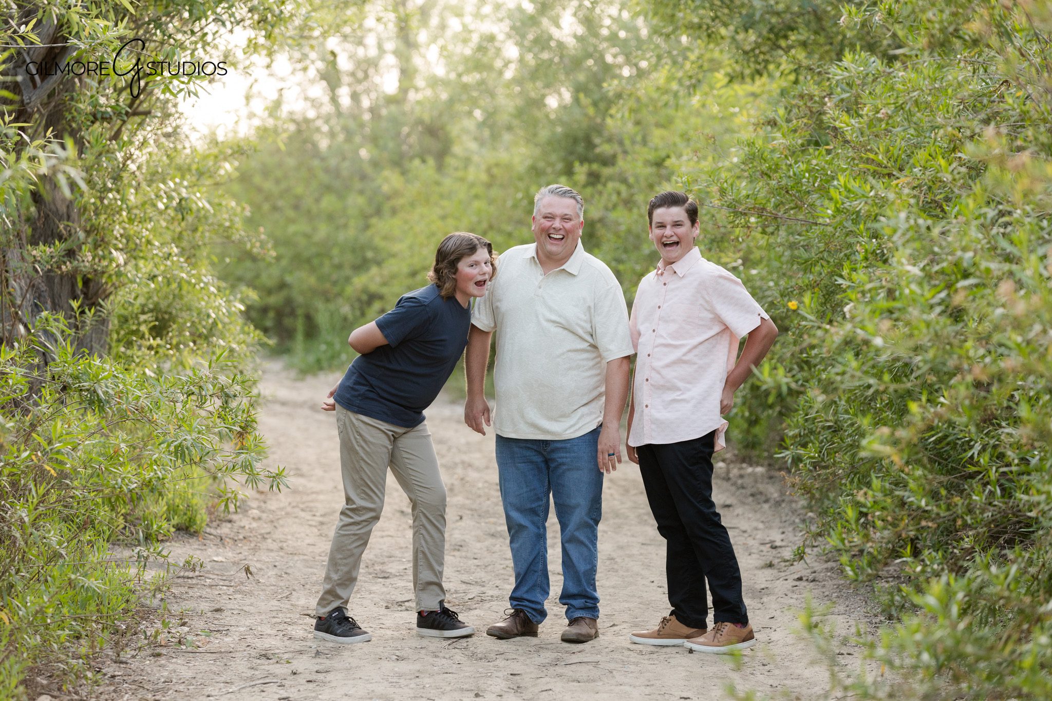 Sibling photos at 19th Street Park with natural greenery in the background
Family walking hand in hand during a park photo session in Newport Beach