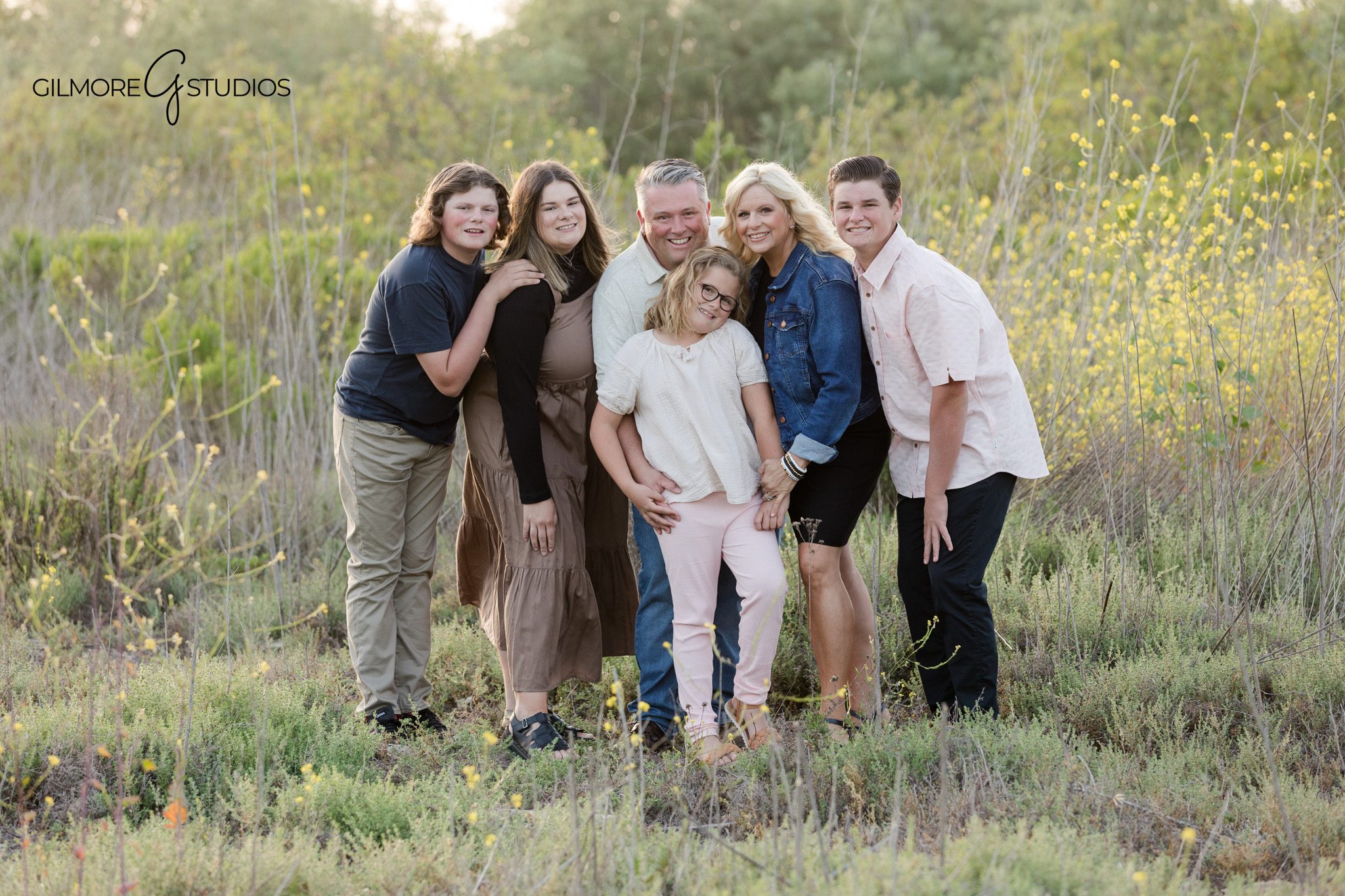Family portraits with wildflowers at 19th Street Park in Newport Beach
Golden hour park session with parents and children walking together