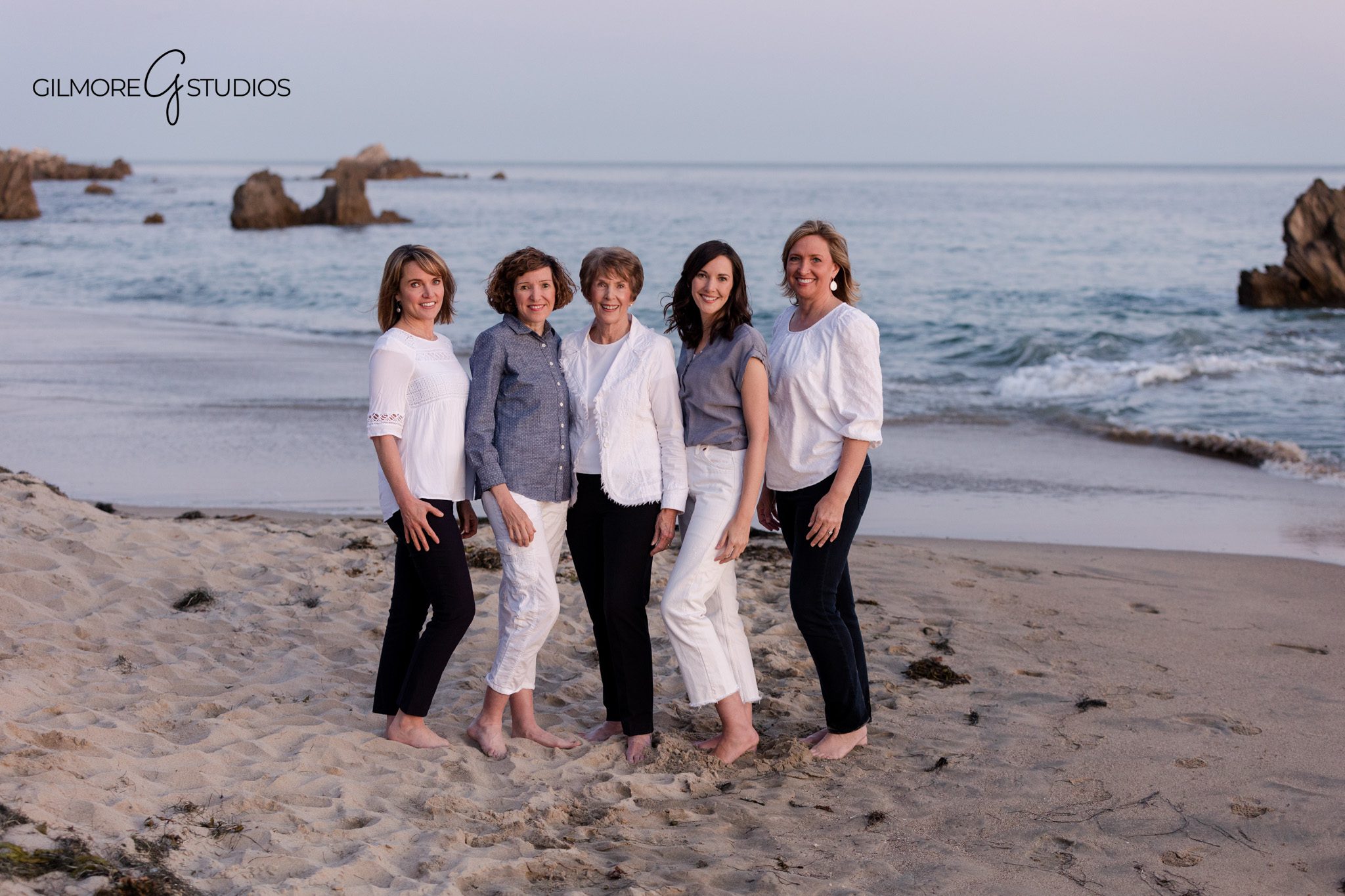 Big Corona Beach family portraits with kids walking barefoot on the sand
Corona del Mar beach session with parents and children near the shoreline