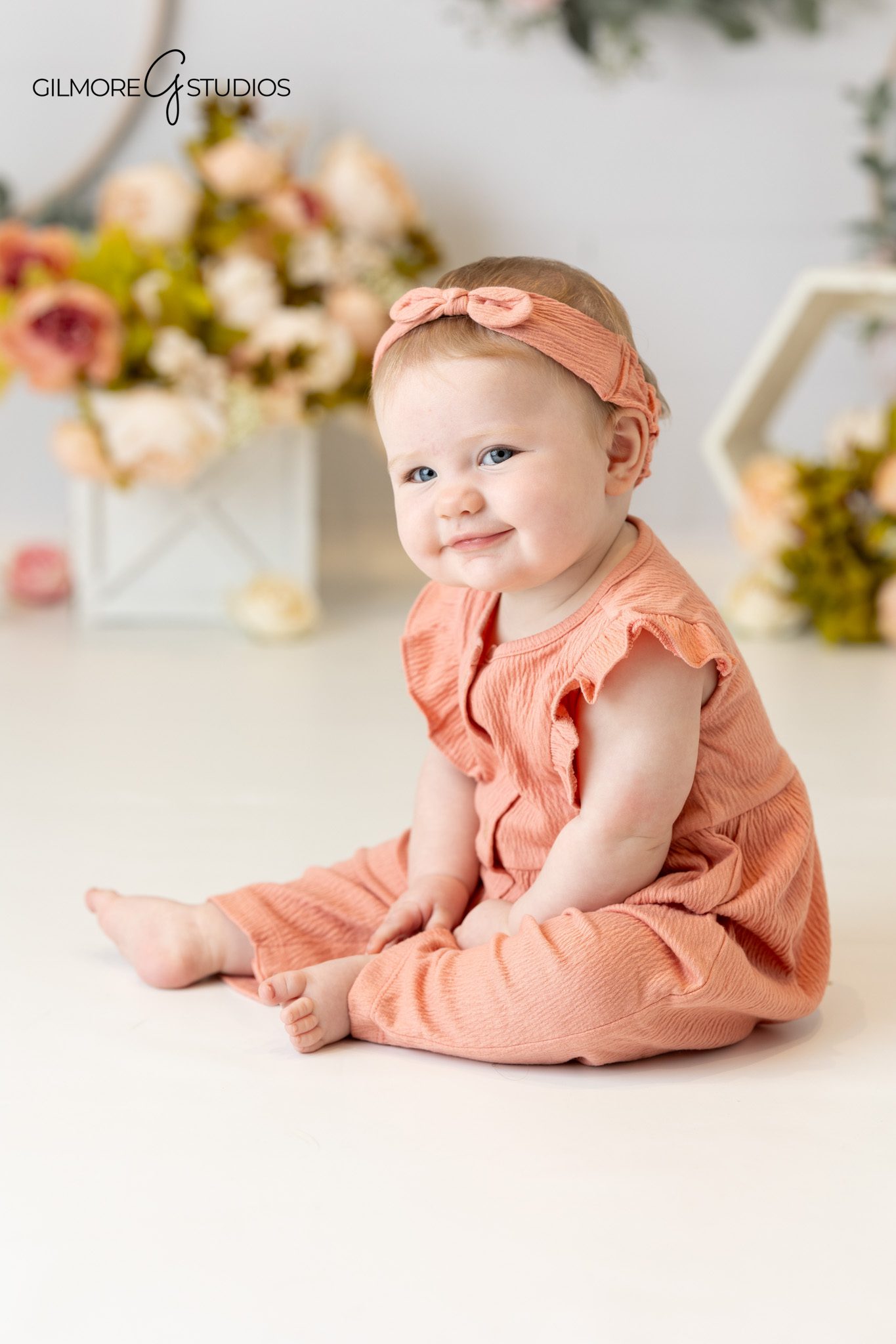Baby sitting up on a soft cream blanket for milestone photos
6 month baby photos with simple neutral studio styling