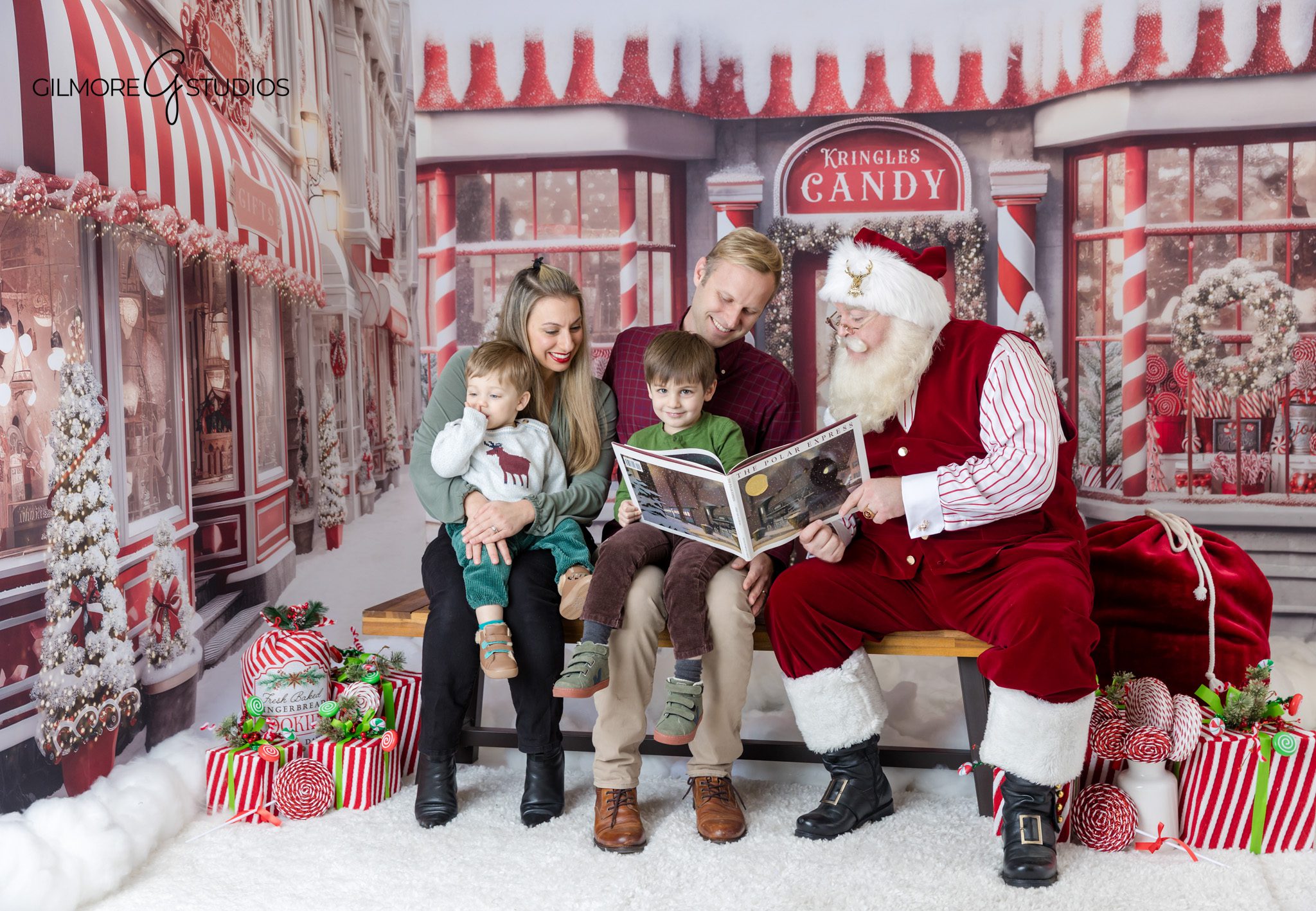 Santa mini session with young children and parents at Gilmore Studios
Family smiling with Santa during Christmas mini session