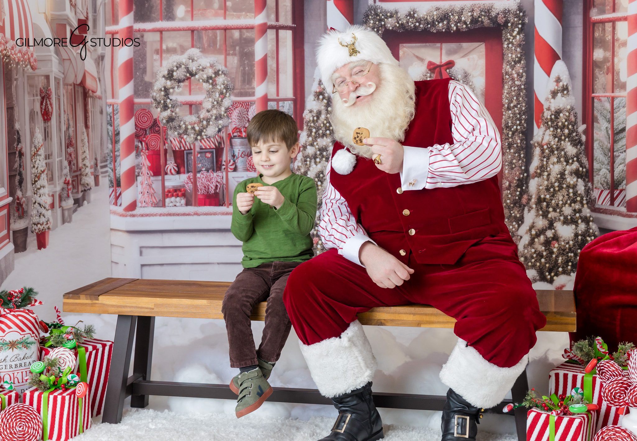 Child smiling with Santa during Christmas photo session
Gilmore Studios Santa mini session with festive gifts and candy props