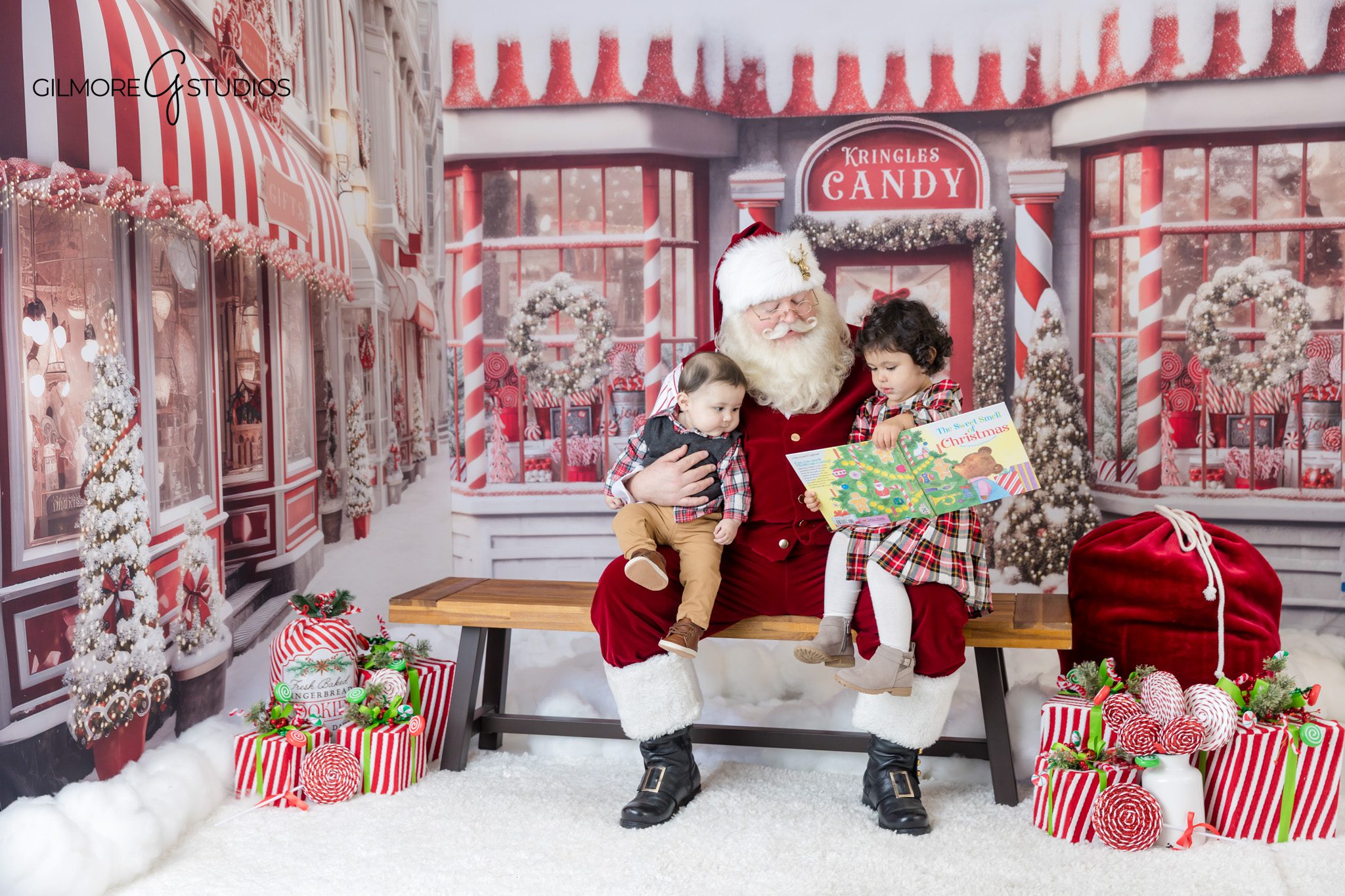 Holiday mini session with Santa in candy shop Christmas backdrop
Santa holding child during Gilmore Studios Christmas session