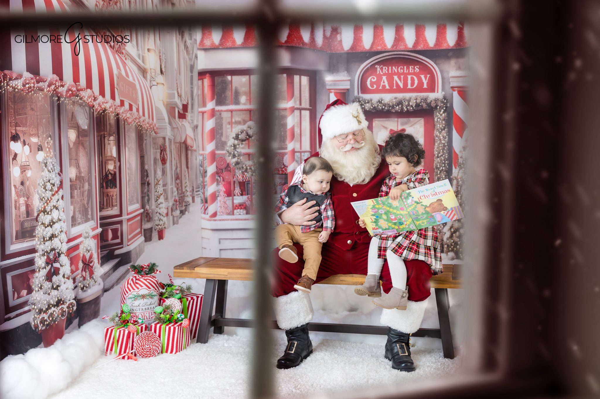 Child sitting with Santa in festive candy shop set
Toddler and older brother photographed with Santa