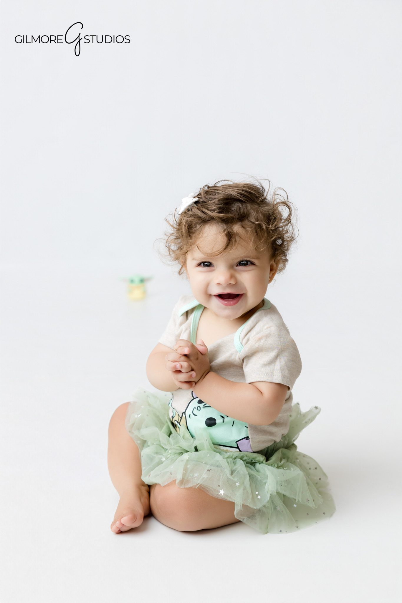 Grogu inspired first birthday photos with baby in soft green outfit
Baby Yoda cake smash session with baby crawling toward her parents