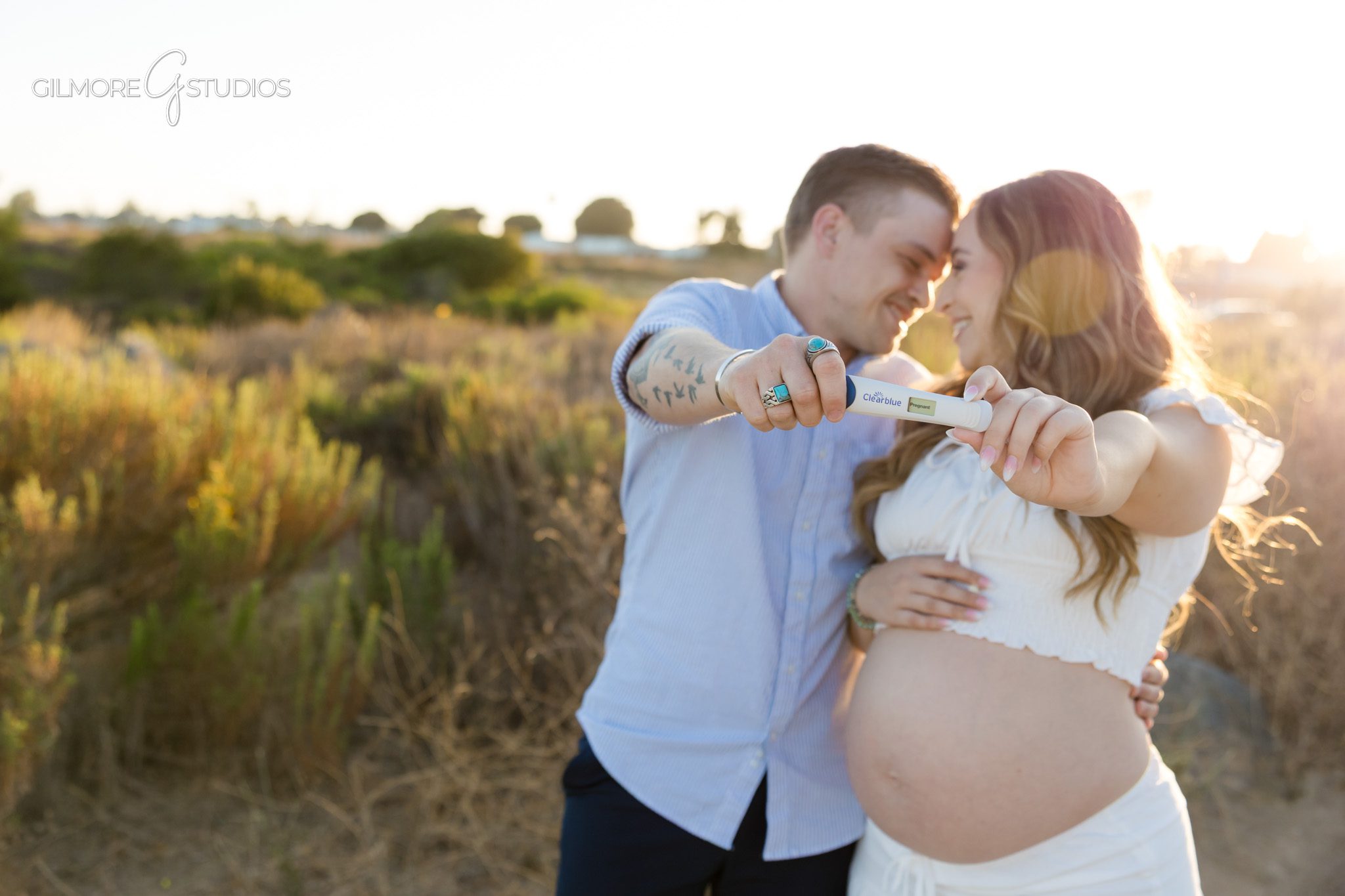 Newport Beach maternity photographer capturing hands on baby bump with ring
Back Bay maternity session with proposal near trees and water views