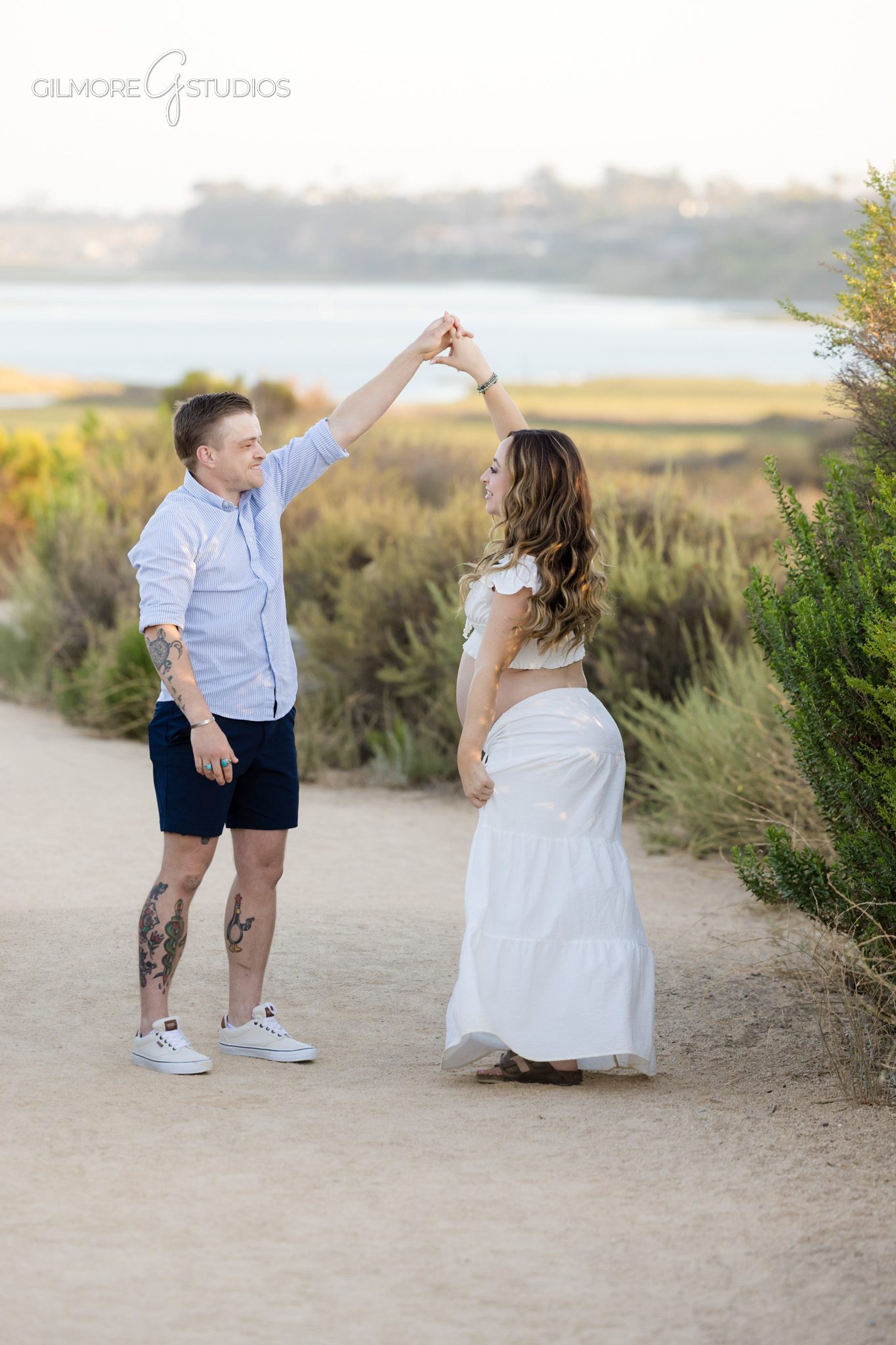 Maternity proposal photos at the Newport Beach Back Bay with soft evening light
Couple holding hands before surprise proposal during Newport Beach maternity photos