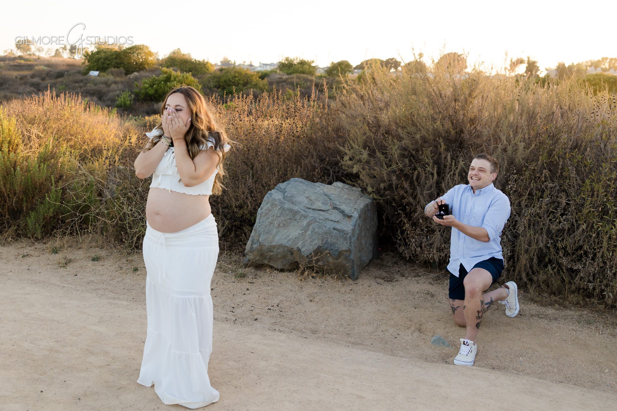 Expecting parents smiling together after surprise engagement in Newport Beach
Maternity proposal session with baby shoes and engagement ring detail