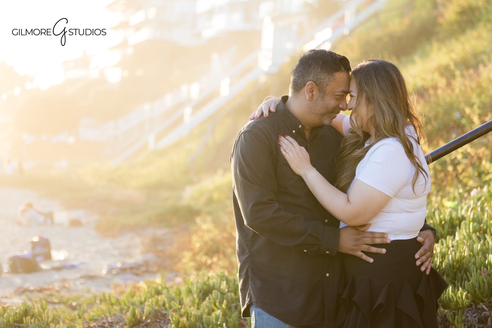 Parents holding hands with child on Big Corona Beach shoreline
Golden hour beach portraits with family walking on wet sand