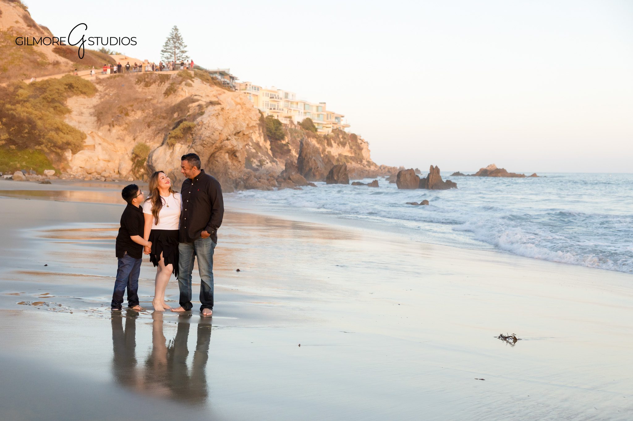 Child laughing with parents during Big Corona Beach family photos
Family photos at Corona del Mar State Beach with pastel sunset sky