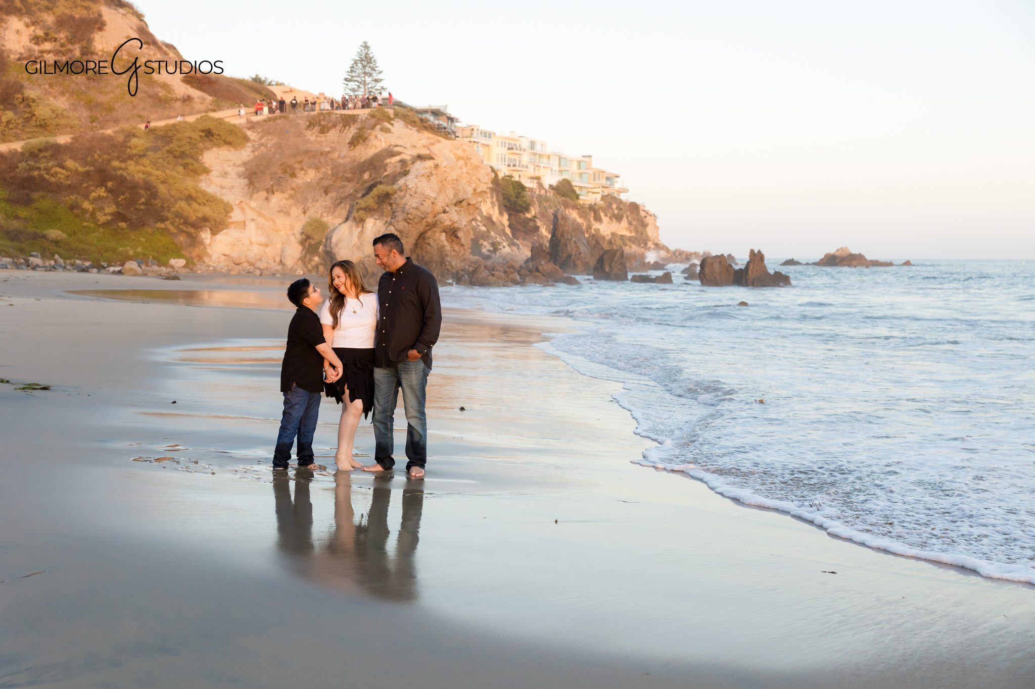 Golden hour family session with parents and child holding hands
Big Corona Beach family portraits with classic coastal scenery