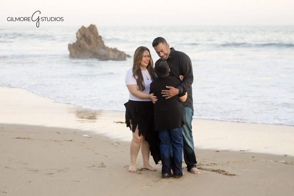 Family portraits at Big Corona Beach with soft coastal wardrobe
Sunset family photos in Corona del Mar with ocean and cliffs behind them
