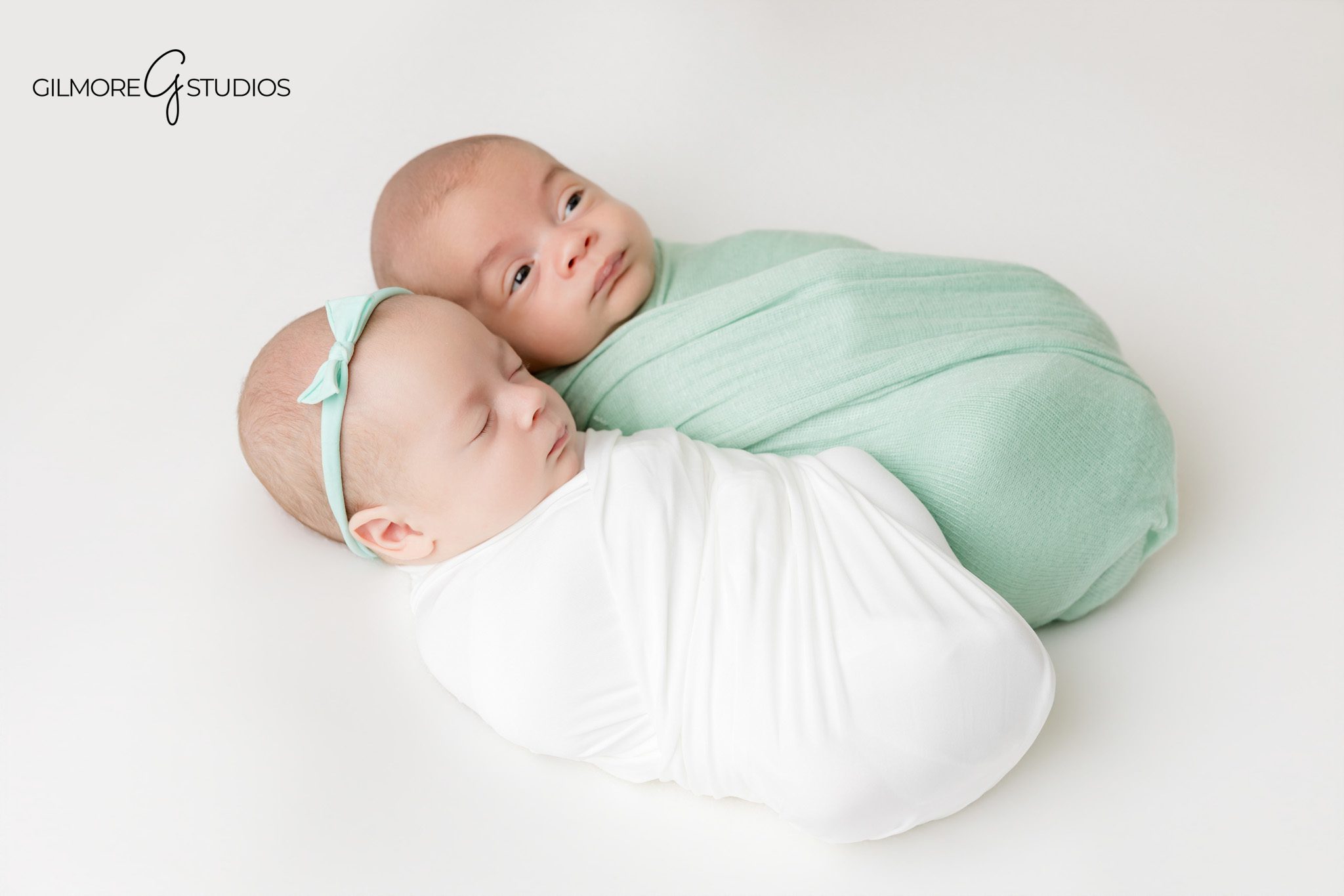 Newborn twins lying side by side in soft white wraps
Gilbert newborn photography session for twins and family