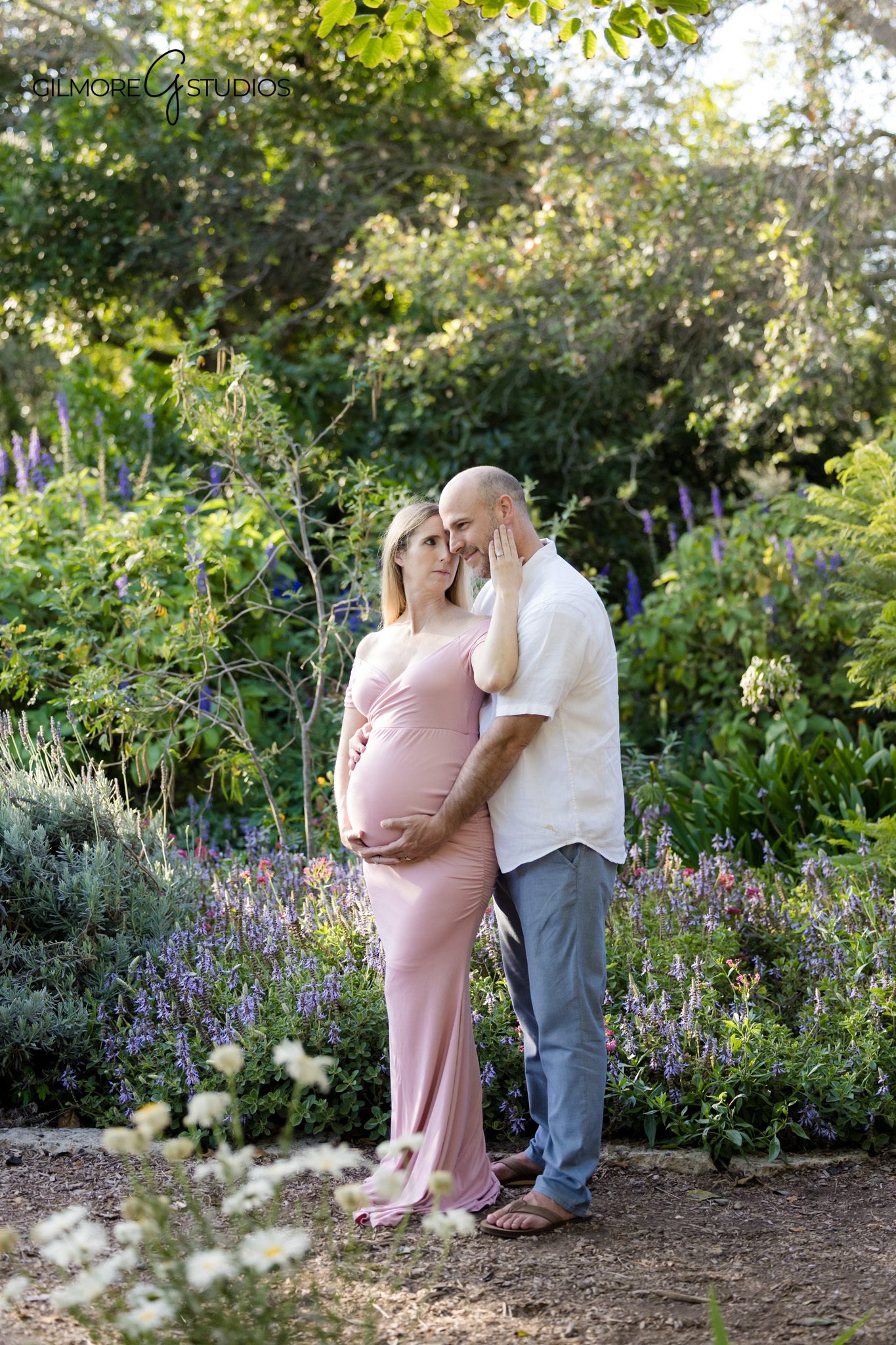 Family maternity photos with toddler in golden hour light
Partner kissing baby bump during Huntington Beach maternity portraits