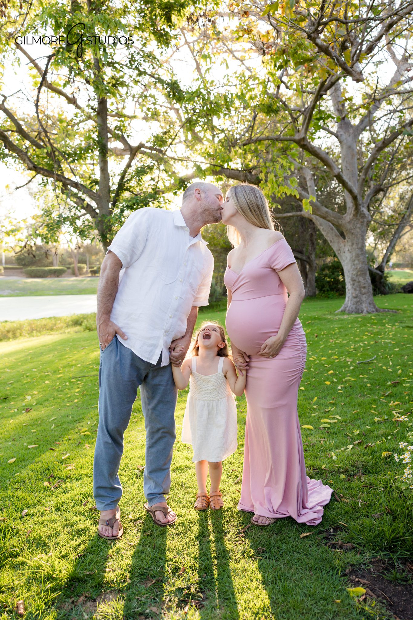 Expecting mother standing in wildflowers at Huntington Beach Central Park
Family walking together during maternity photos in Huntington Beach
