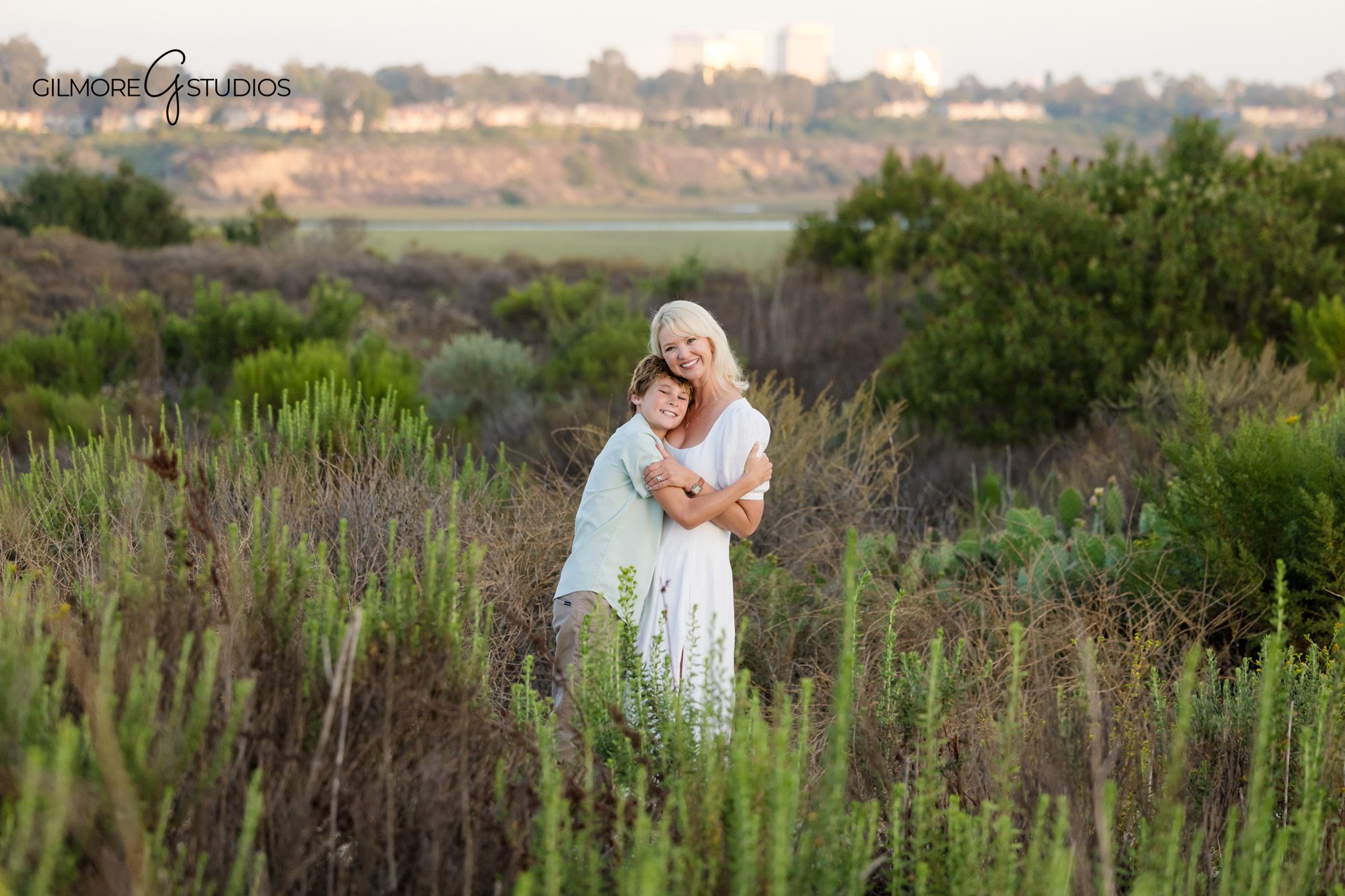 Mom and sons portrait during Back Bay family session
Mother receiving kisses from sons during Newport Beach family photos