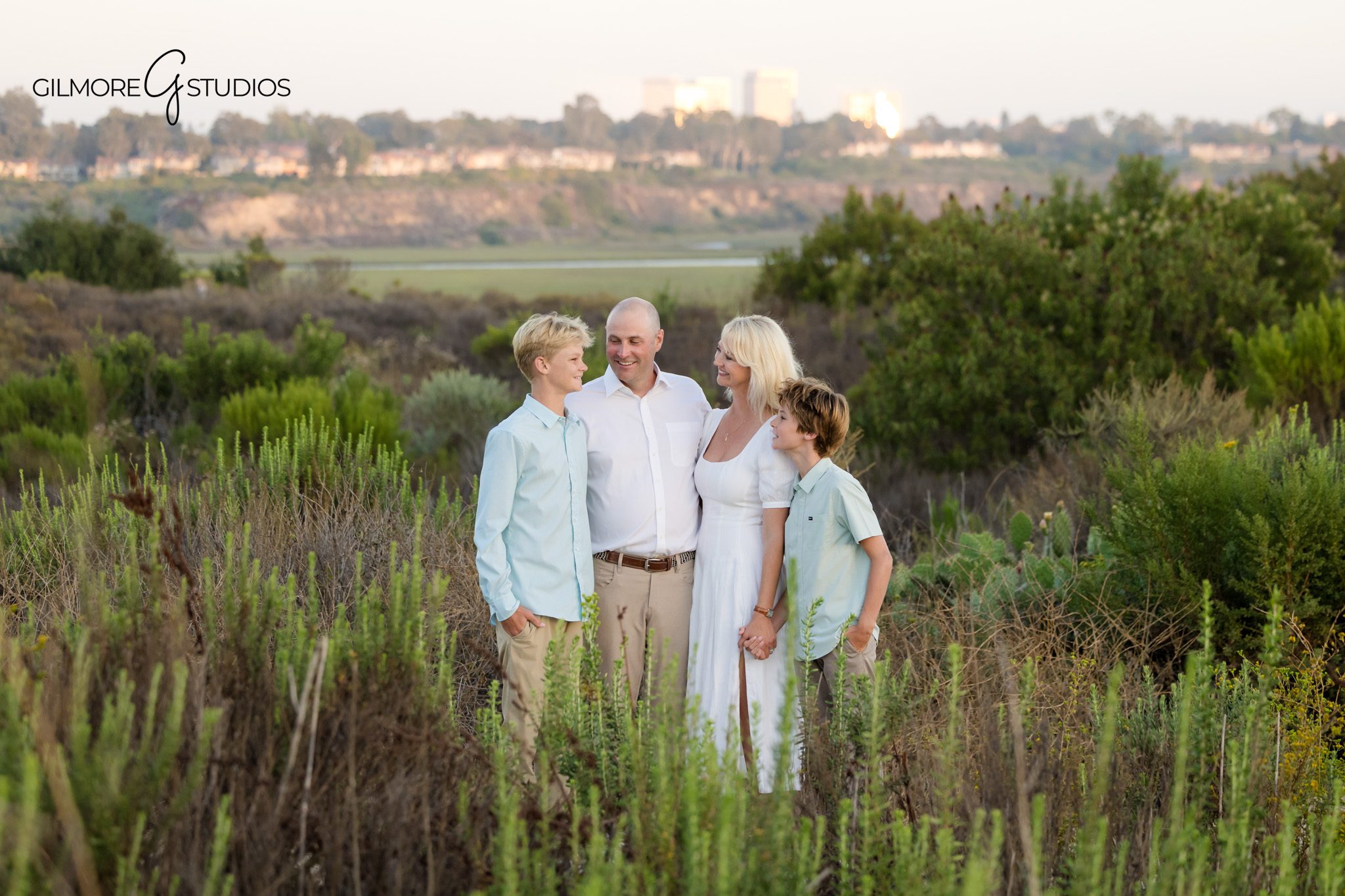 Outdoor family photos in Newport Beach with natural preserve scenery
Back Bay Nature Preserve family portrait with warm sunset glow