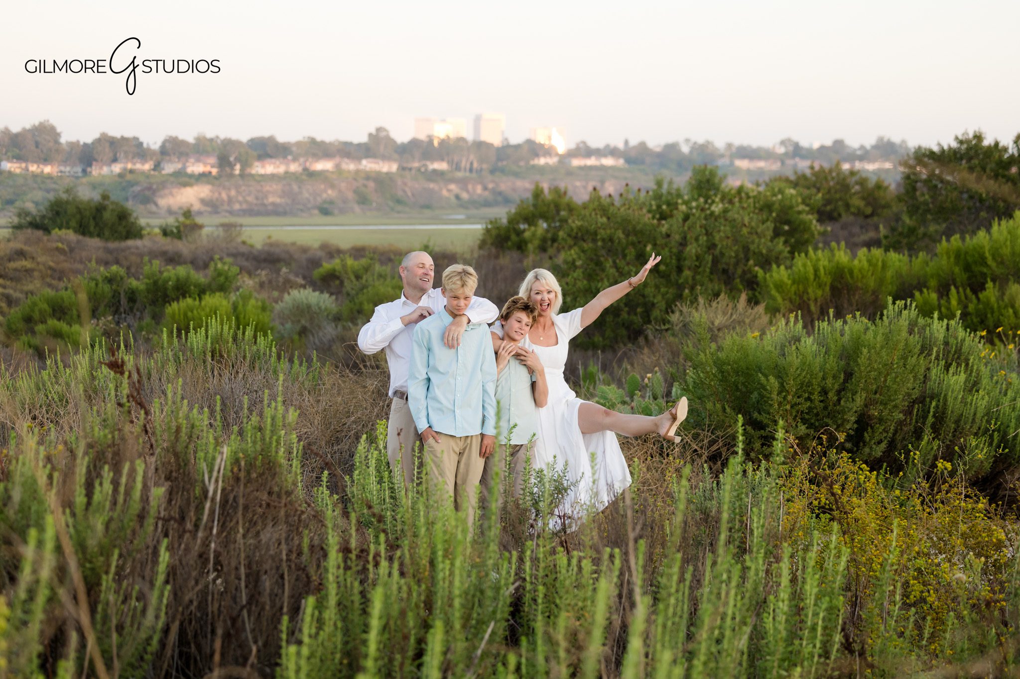Newport Beach family session with boys and parents in coastal setting
Family standing together in golden grass during Back Bay photos