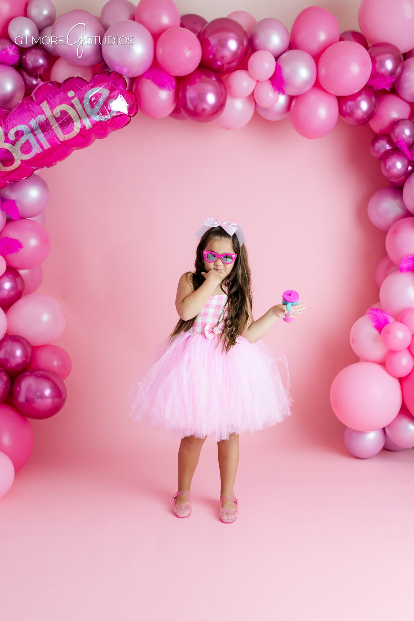 Gilbert AZ milestone birthday photographer capturing playful portraits
Barbie inspired birthday photos with pink balloon garland