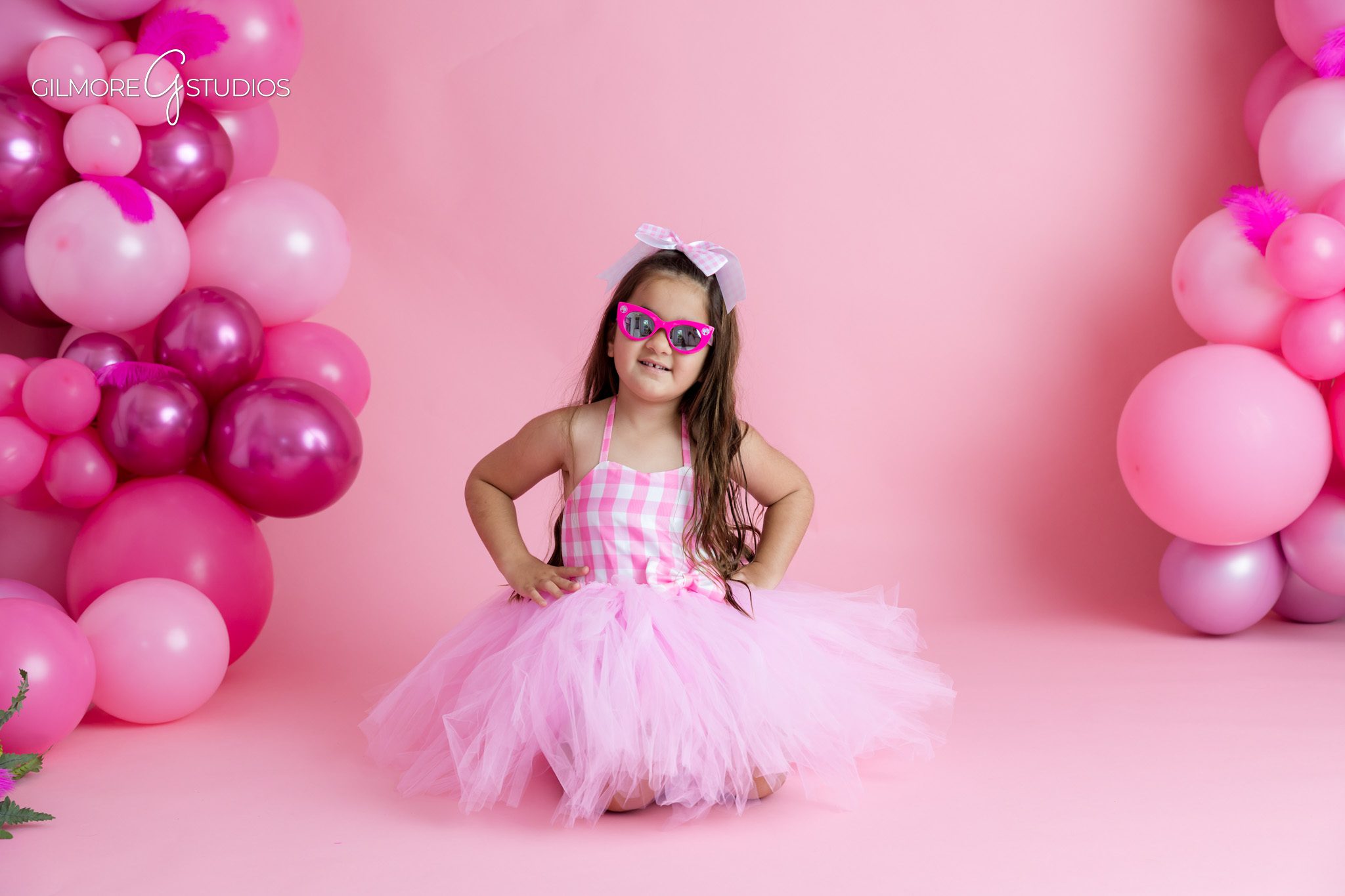Studio birthday photos in Gilbert AZ with pink Barbie theme
Little girl wearing pink sunglasses during 5th birthday photoshoot