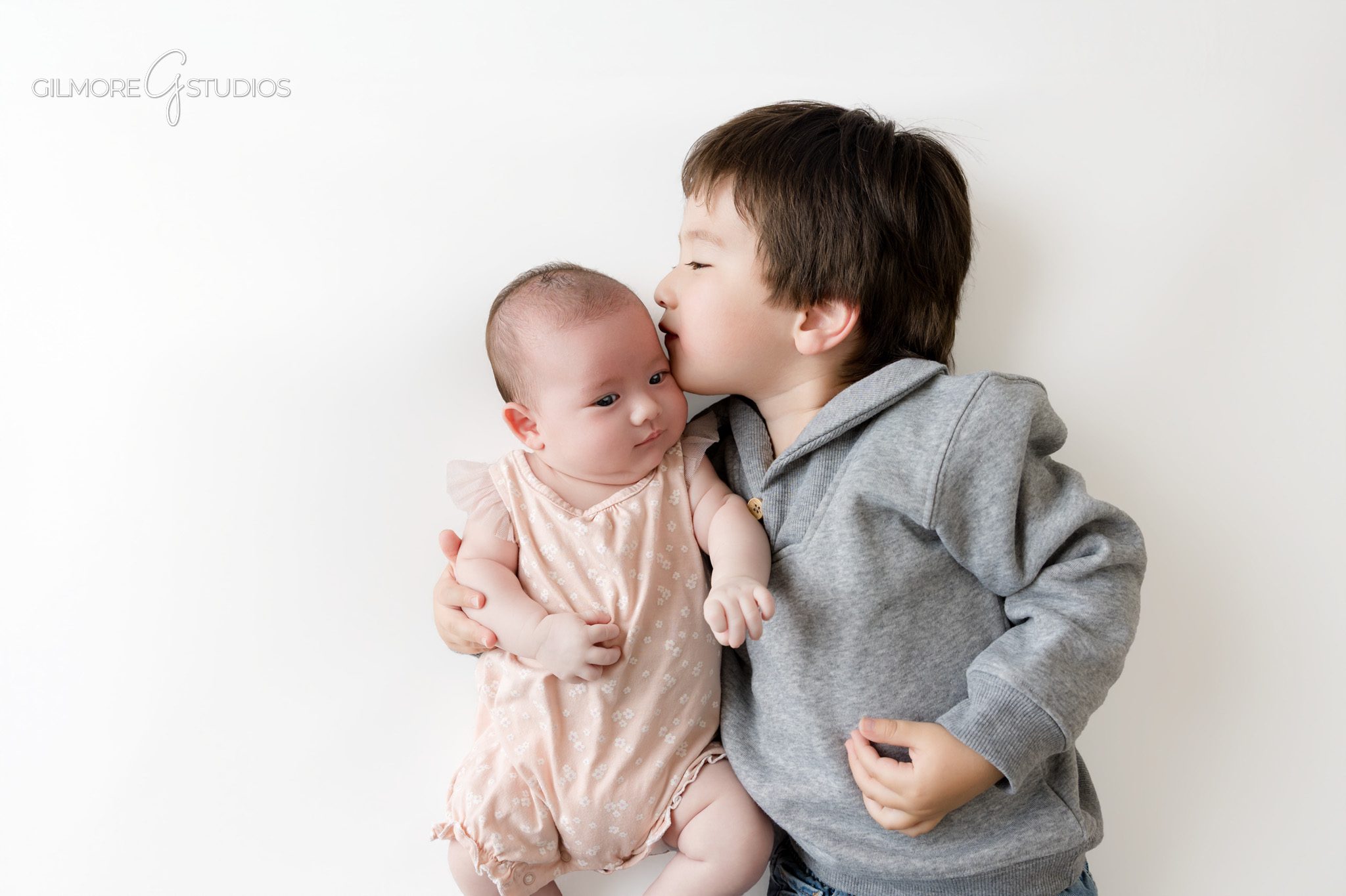 Older newborn photo session with baby girl on white studio background
Baby girl holding felt balloon props during older newborn photos