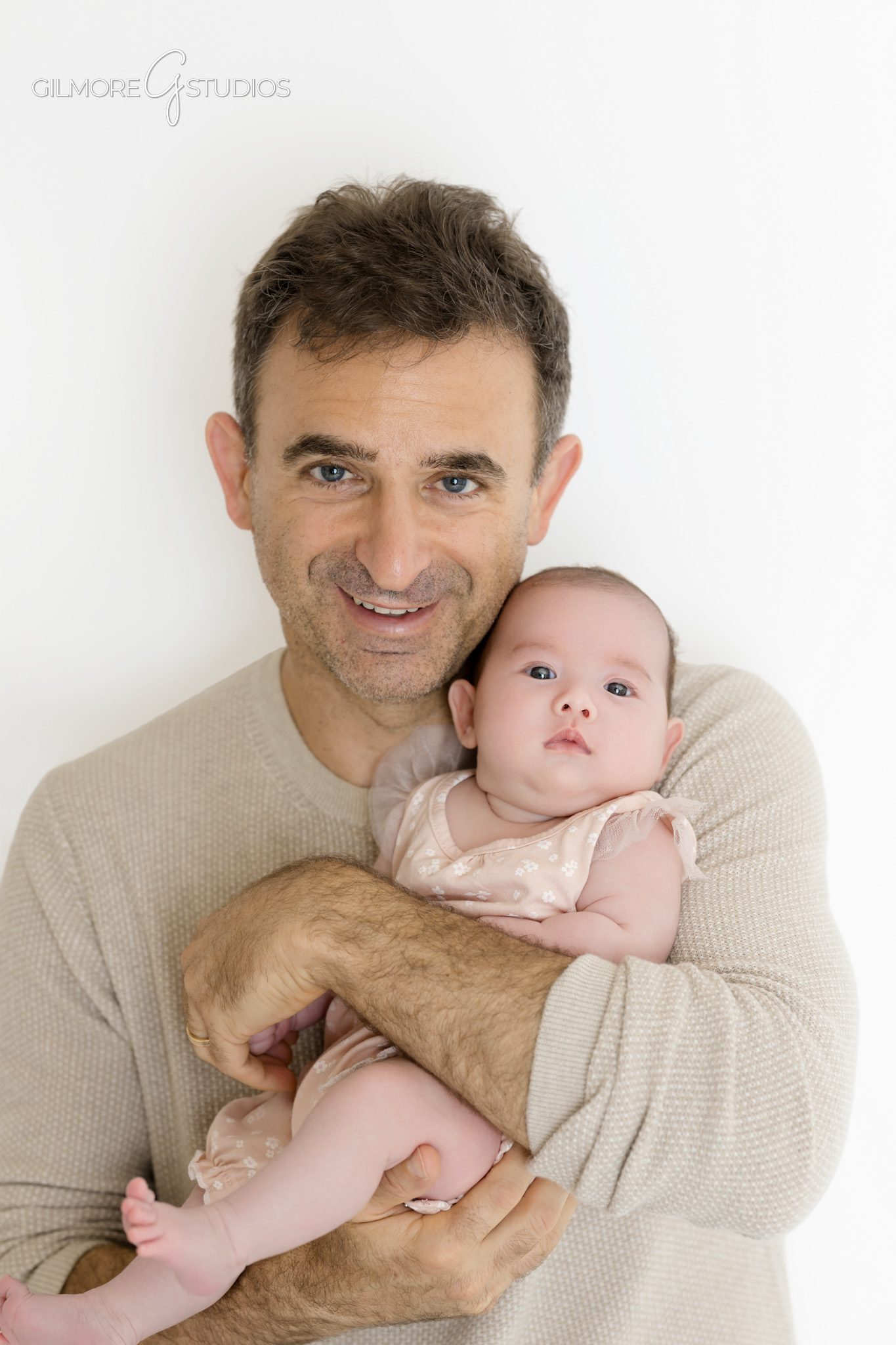 Older newborn baby close up portrait with sweet eye contact
Baby girl lying on white backdrop during Queen Creek baby session