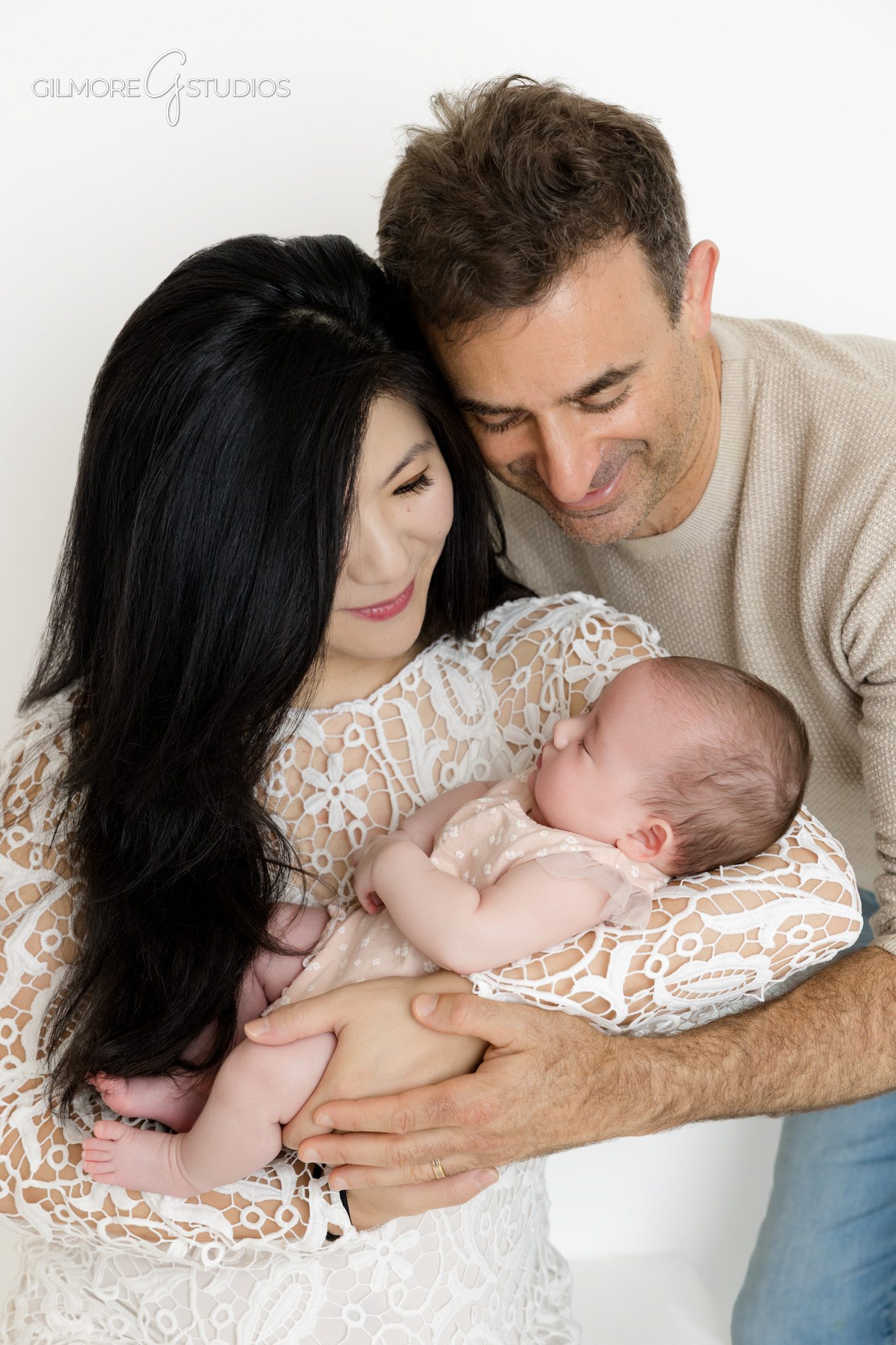 Simple studio portrait of 2 month old baby girl in pink romper
Baby past newborn stage photographed in soft natural studio style