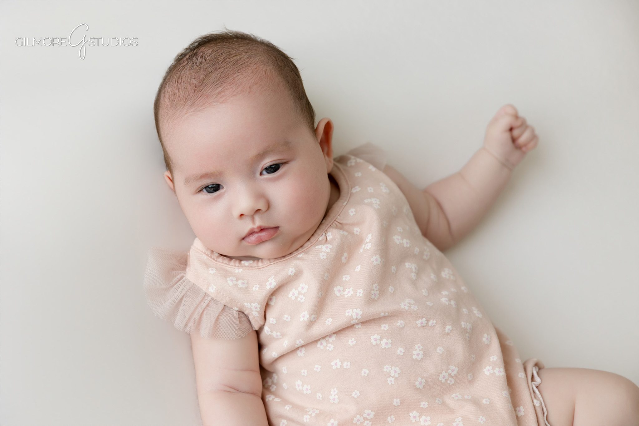 Baby girl and big brother photographed together in soft studio light
Older sibling kissing baby sister during newborn inspired studio session