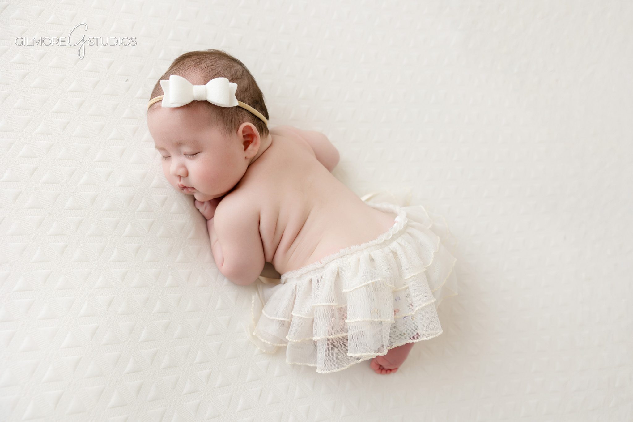 Baby girl wrapped in blush pink during Queen Creek newborn photos
Older newborn baby wearing floral headband in pink wrap