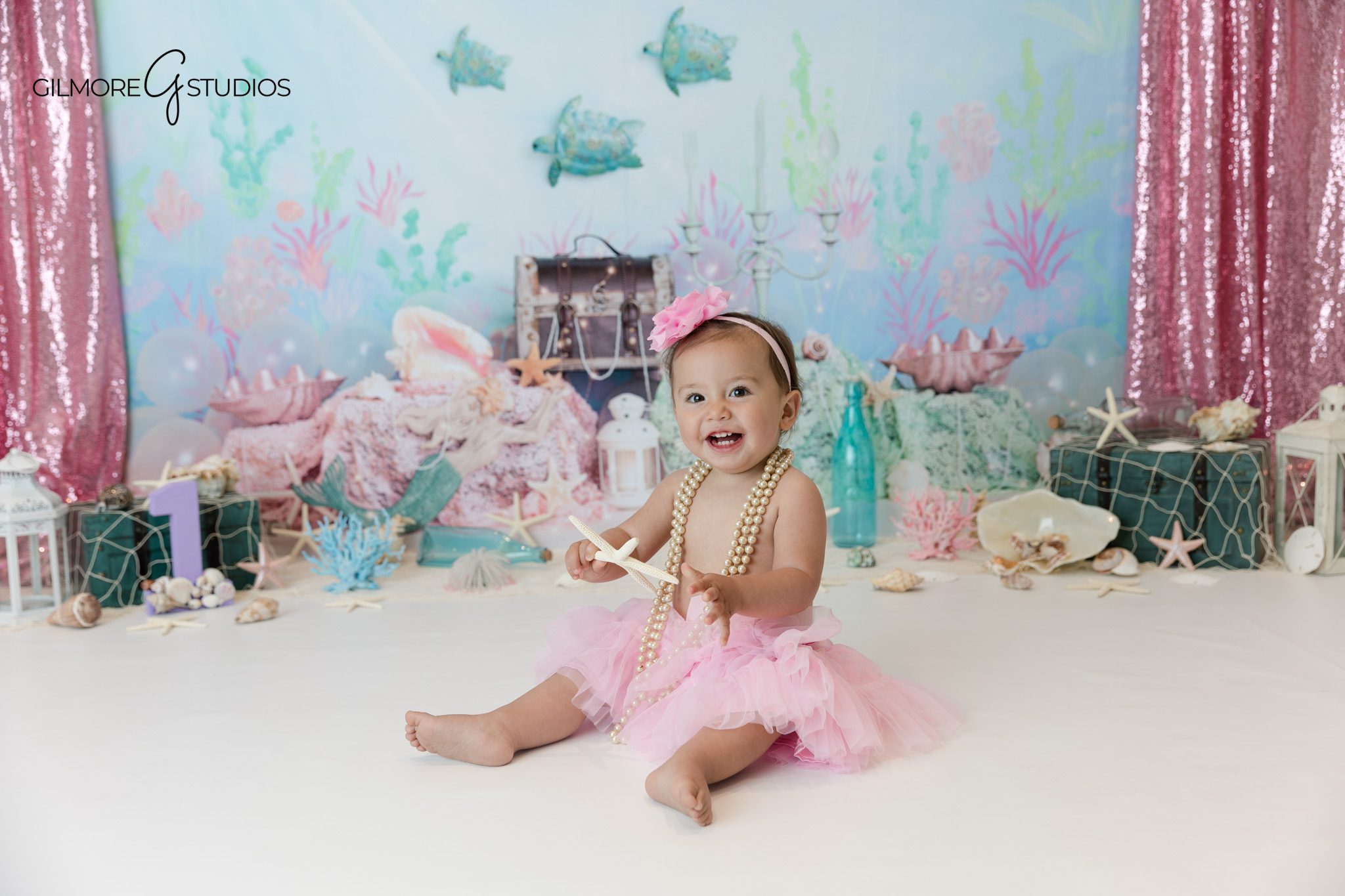 First birthday photos with seashells pearls and mermaid inspired details
Gilmore Studios themed birthday session with under the sea backdrop