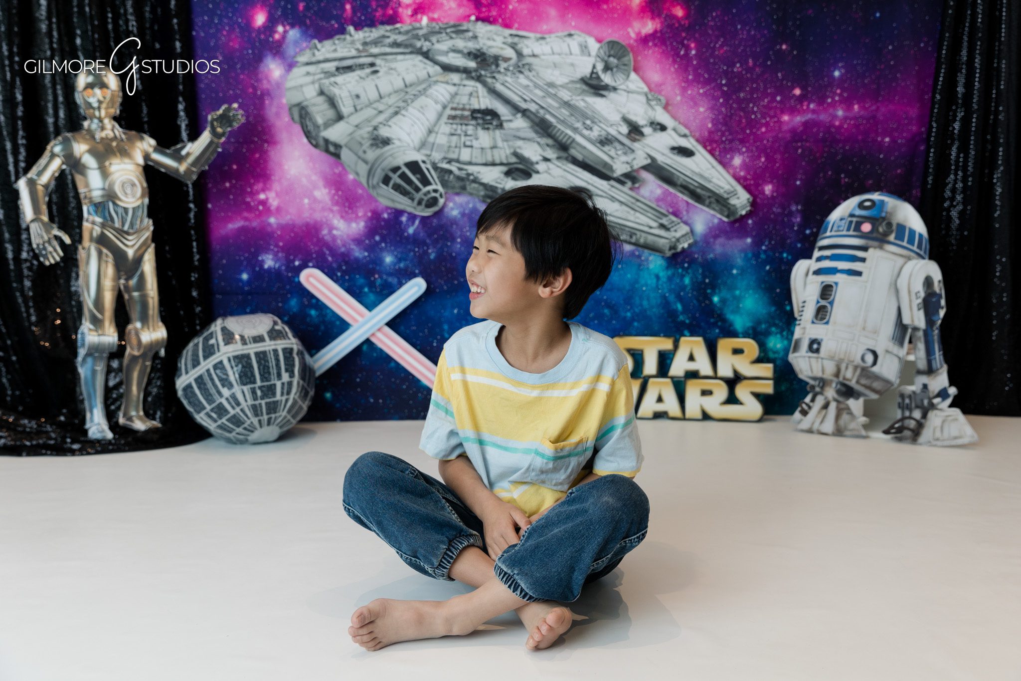 Gilmore Studios themed session with galaxy birthday setup
Child smiling in front of spaceship and robot backdrop