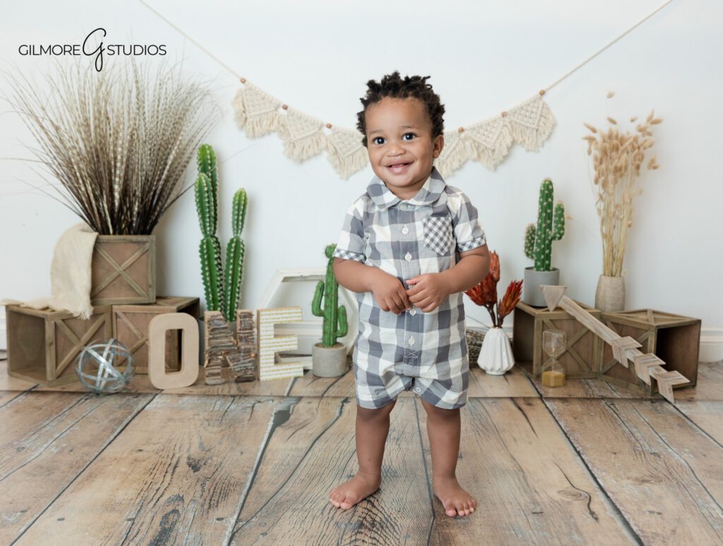 Outdoor first birthday portrait with greenery in Newport Beach
Baby boy in gray plaid romper during Newport Beach birthday photos