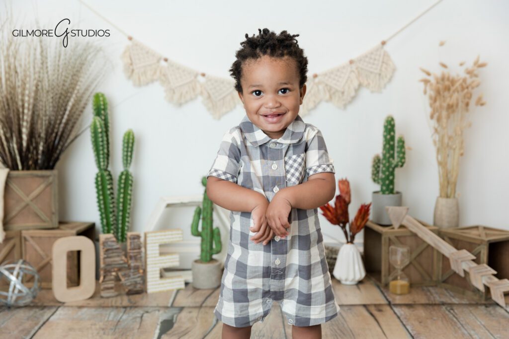 Baby boy smiling on grass before his boho cake smash session