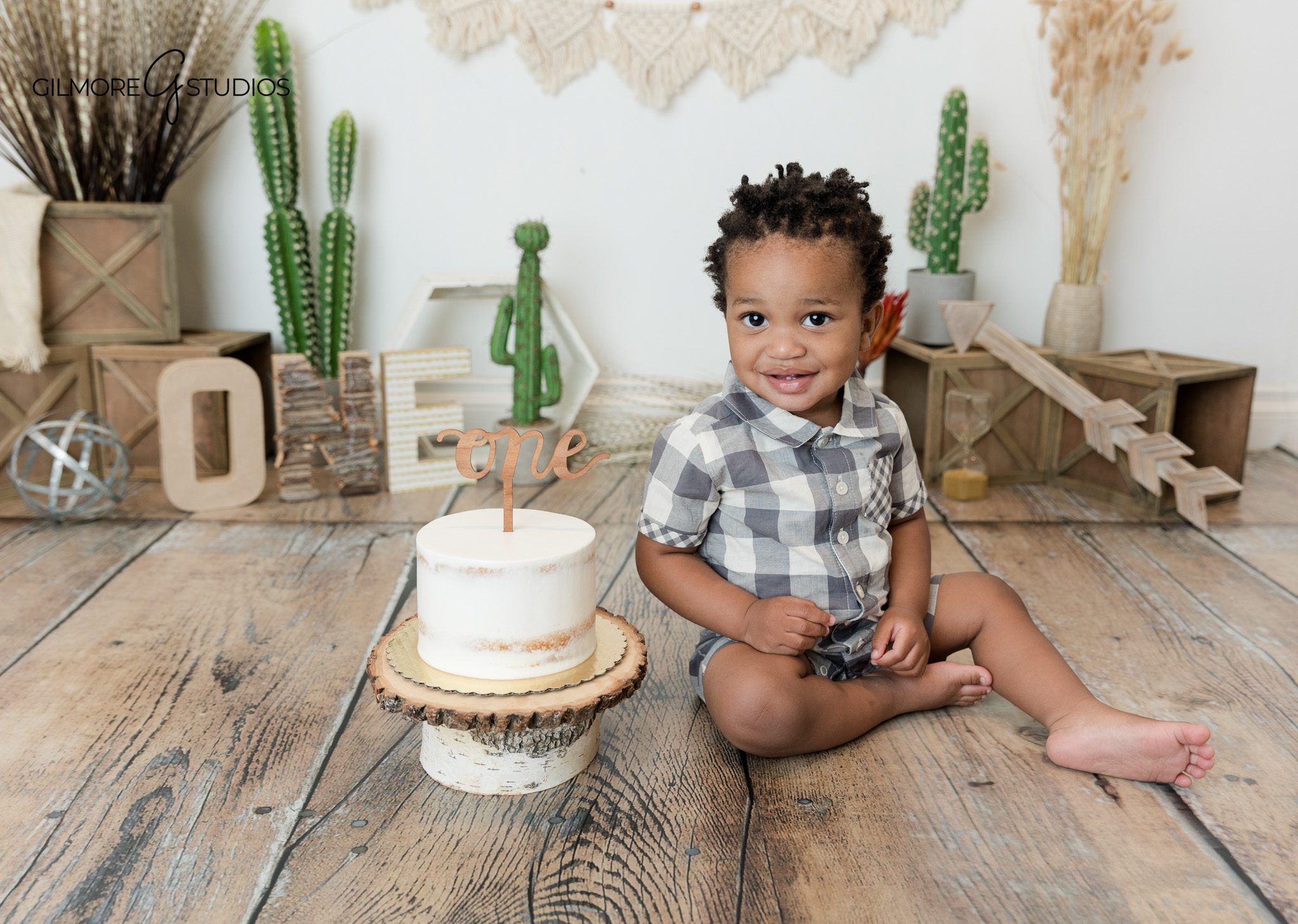 Natural light baby portrait in Newport Beach garden setting
Baby boy smiling in gray plaid outfit for boho birthday photos